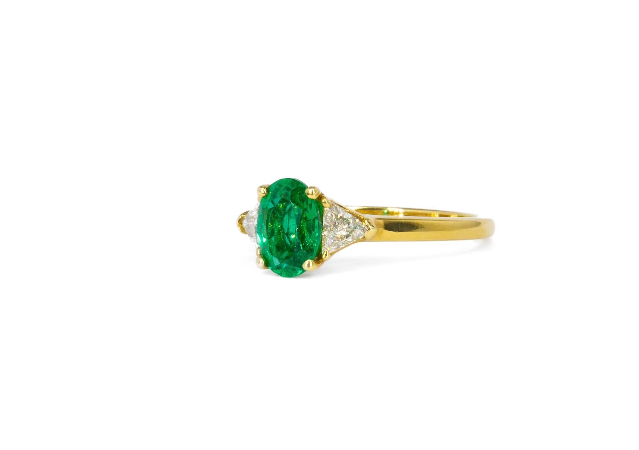 Este exquisito Anillo de Tres Piedras Kurt Wayne de Esmeralda Ovalada y Diamante de 0,79 quilates es una mezcla atemporal de elegancia y arte. En su centro hay una vibrante esmeralda ovalada de 0,79 quilates, que irradia un rico tono verde que