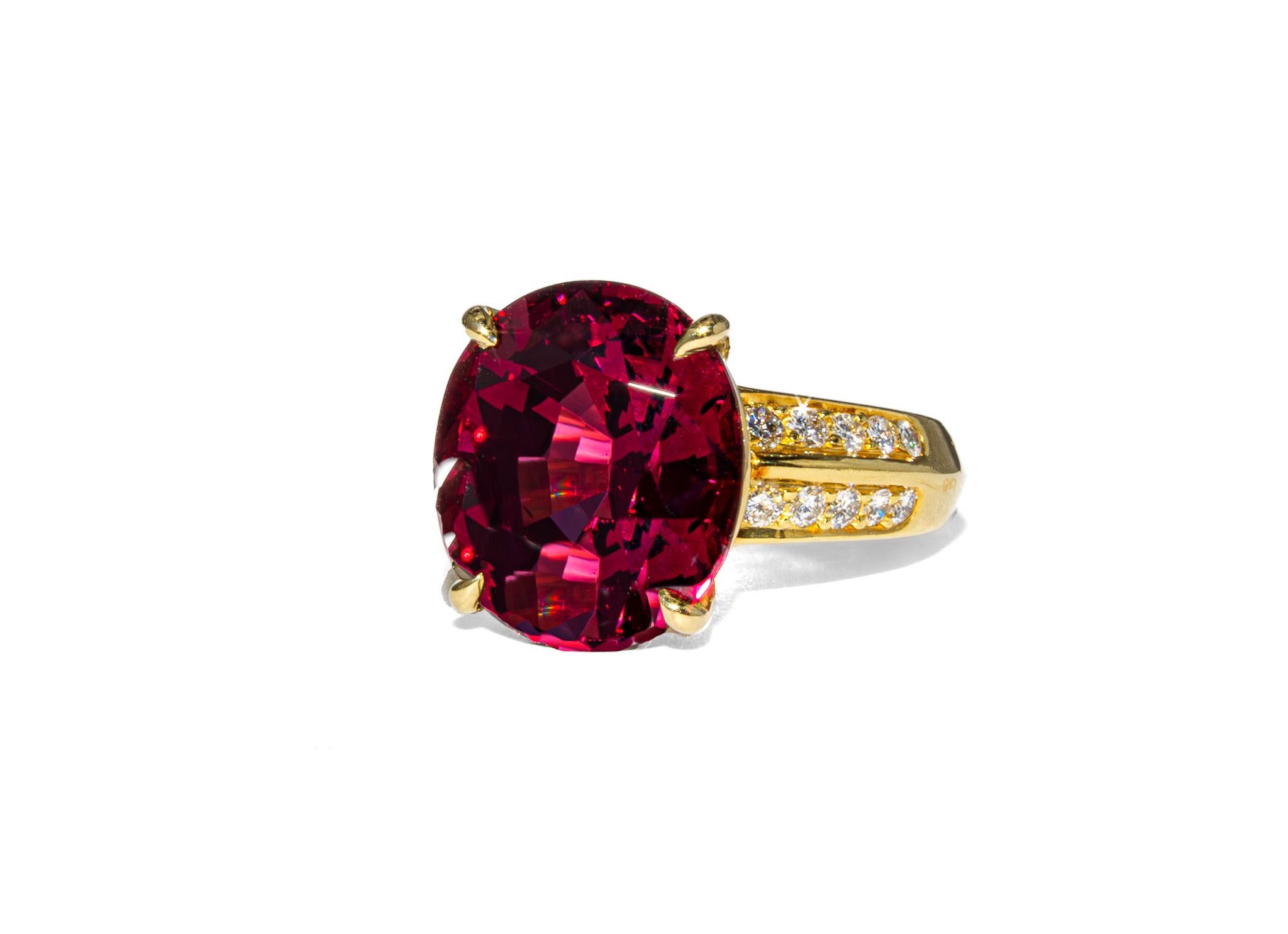This striking cocktail ring is a bold celebration of color and elegance. Crafted in 18K yellow gold, it features an impressive 11.42 carat oval rhodolite garnet with a rich, raspberry hue that’s both regal and romantic. The gemstone is beautifully