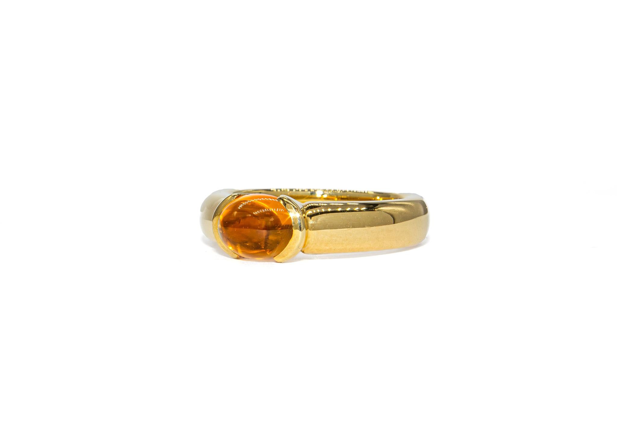 This vibrant ring by Kurt Wayne brings a warm, golden glow to any collection. The center stone is a 1.44 carat cabochon citrine with a luminous, honeyed tone and smooth, polished surface that catches and reflects the light beautifully. Set in 18K