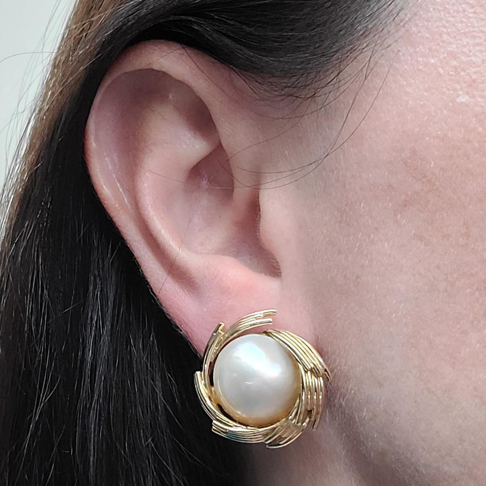 18 Karat Yellow Gold Kurt Wayne Stud Earrings Featuring Two 15mm Mabe Pearls. Pierced Post With Omega Clip Back. Post Can Be Removed Upon Request. Finished Weight is 21.8 Grams.