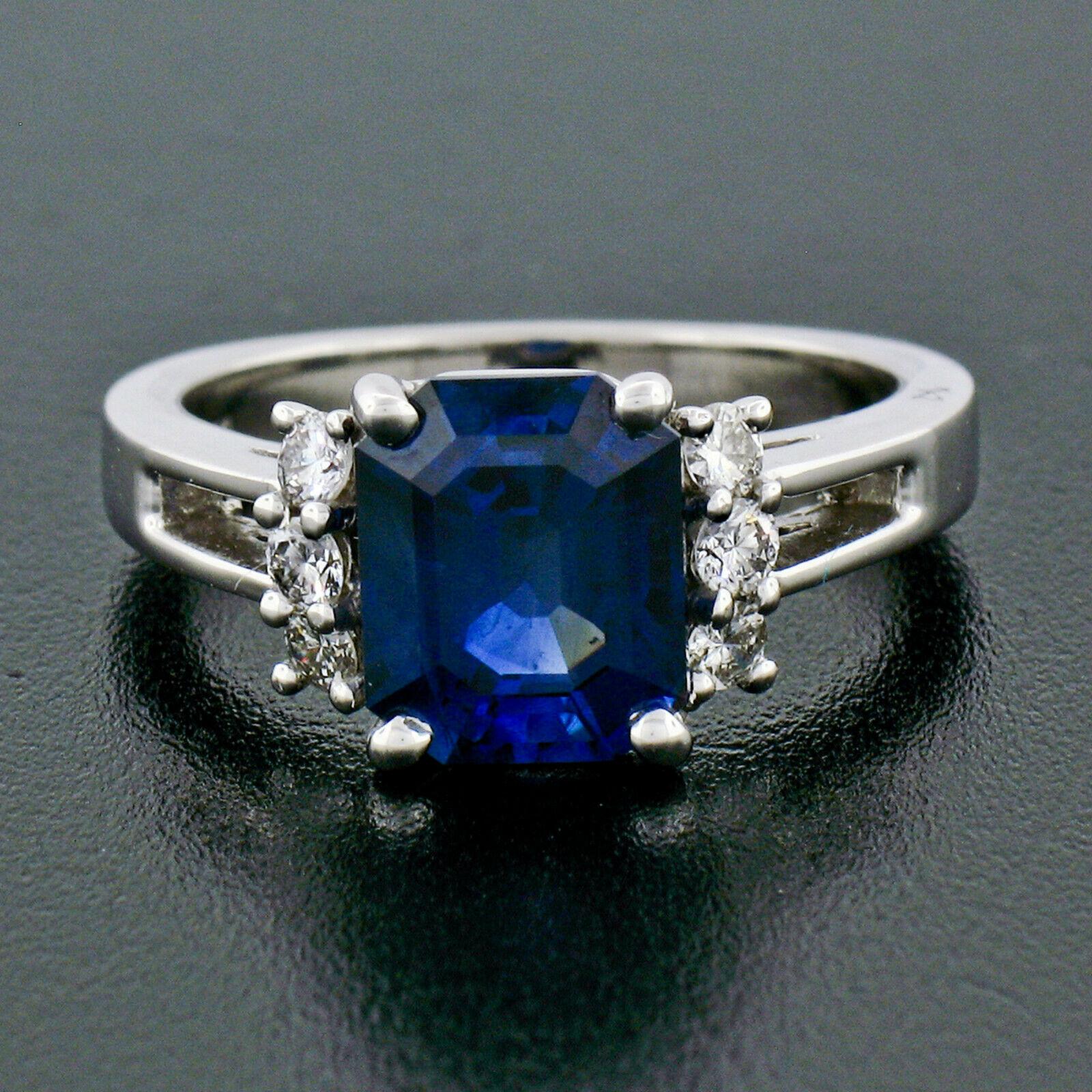This breathtaking sapphire and diamond ring is designed by Kurt Wayne and crafted in solid 18k white gold. It features a gorgeous, AGL certified, genuine sapphire solitaire. The cut-cornered emerald cut sapphire has an amazingly rich royal blue