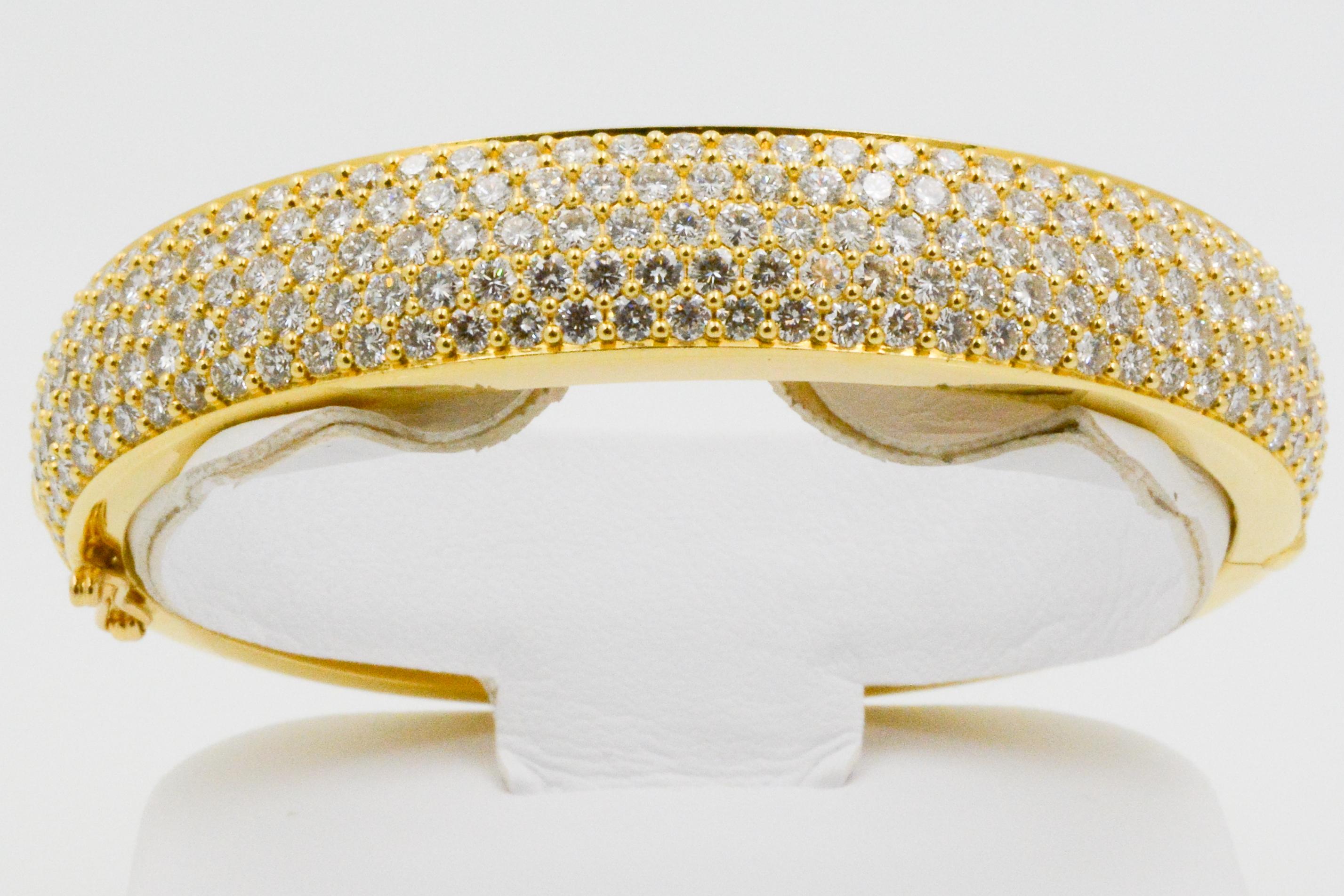 This 18 karat yellow gold Kurt Wayne bangle features a panel of rows of 193 round brilliant pave diamonds, weighing a total of approximately 10.00 carats. Glamorous and enchanting is this bangle; with a tongue & groove clasp with safety, the hinged
