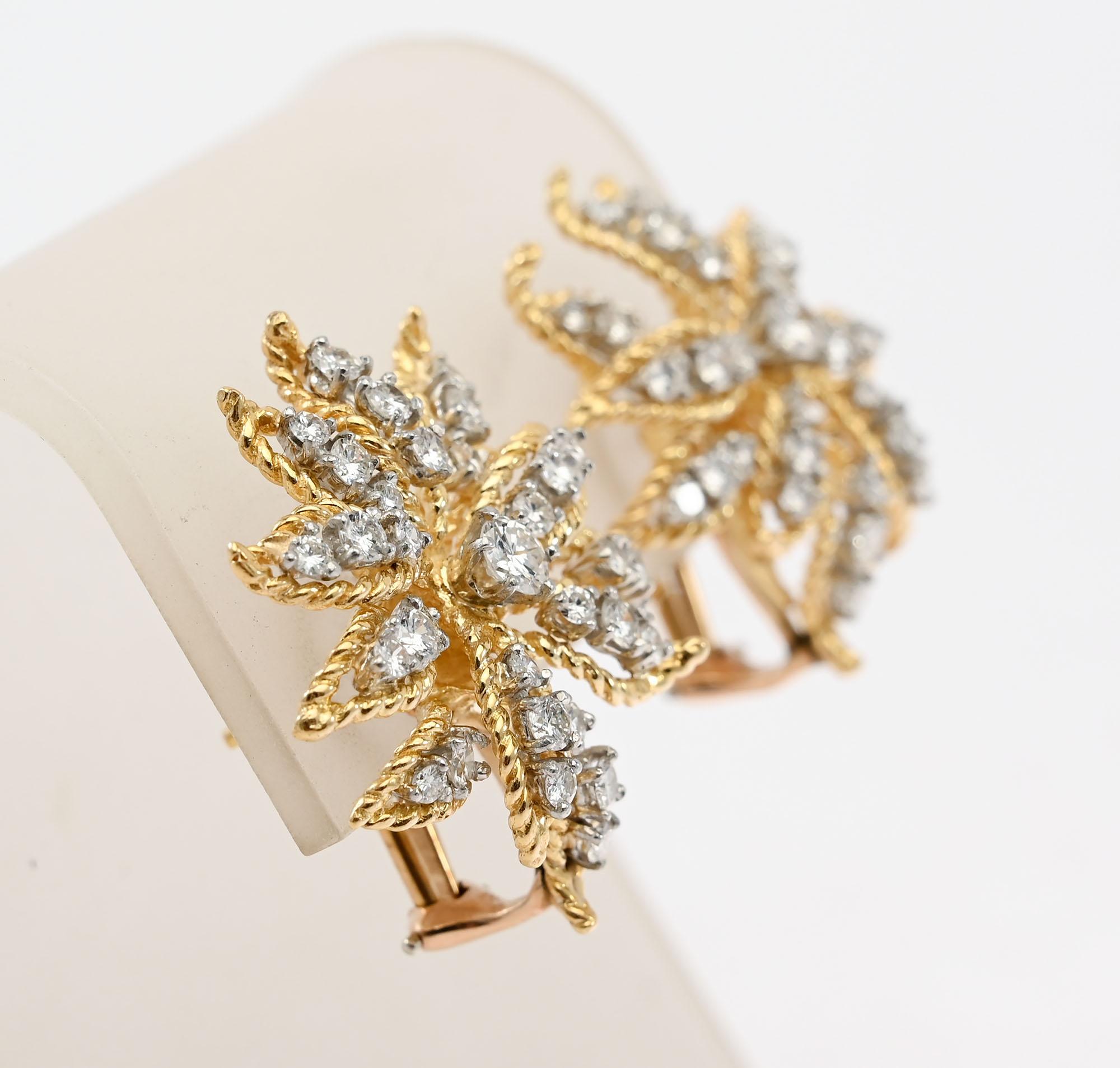 Stunning diamond earrings by Kurt Wayne in the shape of a flower. Each earring has 33 round brilliant diamonds for a total weight of 2.5 carats. Twisted gold frames each of the three dimensional flower petals. Among other things, Wayne is known for