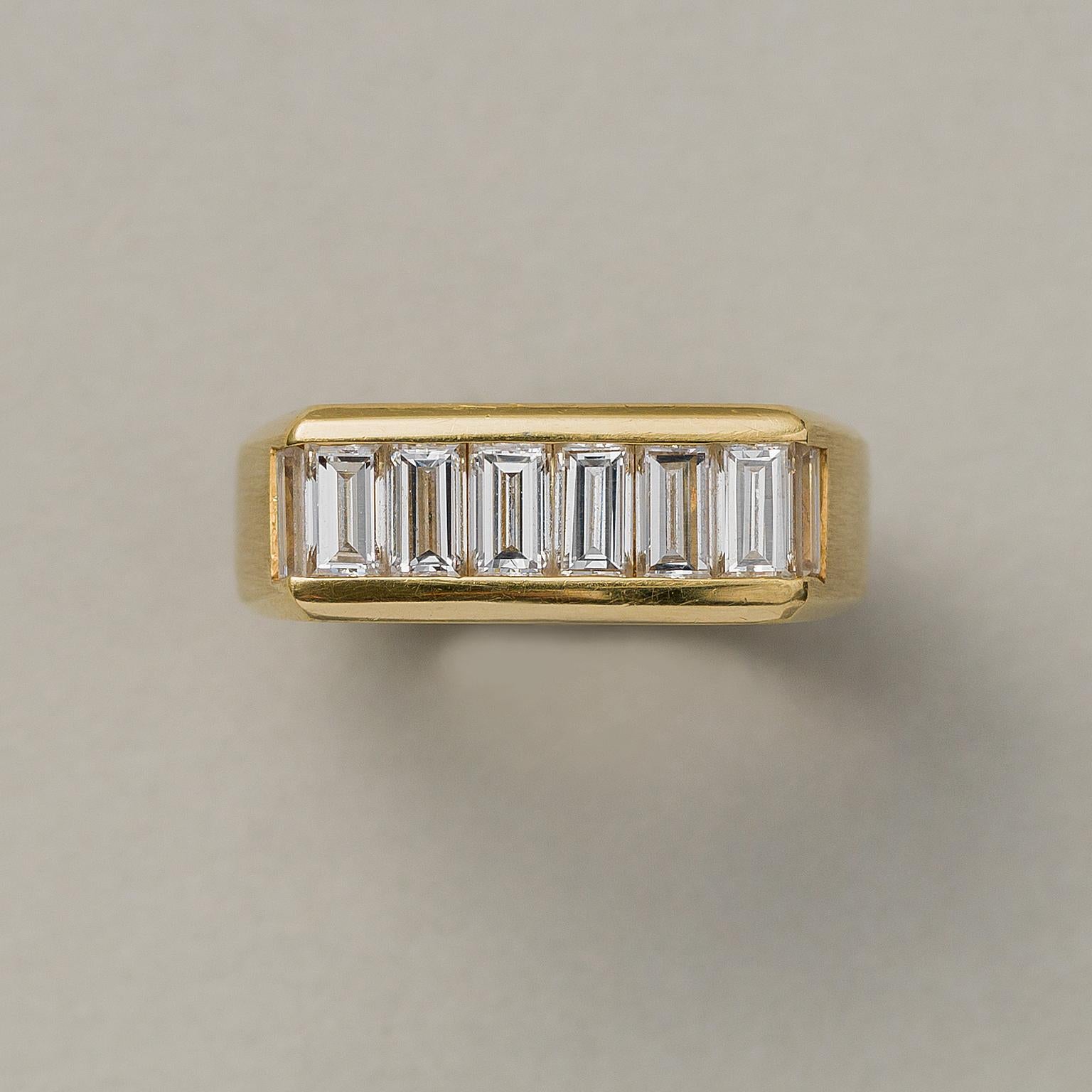 An elegant 18 carat yellow gold band ring with baguette cut diamonds (6 x 0.15 and 2 x 0.11, so app. 1.12 carat in total F-G, VS), signed and numbered Kurt Wayne 44605, circa 1960.

weight: 9.31 grams
ring size: 16.75 mm / 6 ¼ US
width: 6.6 - 4.3 mm