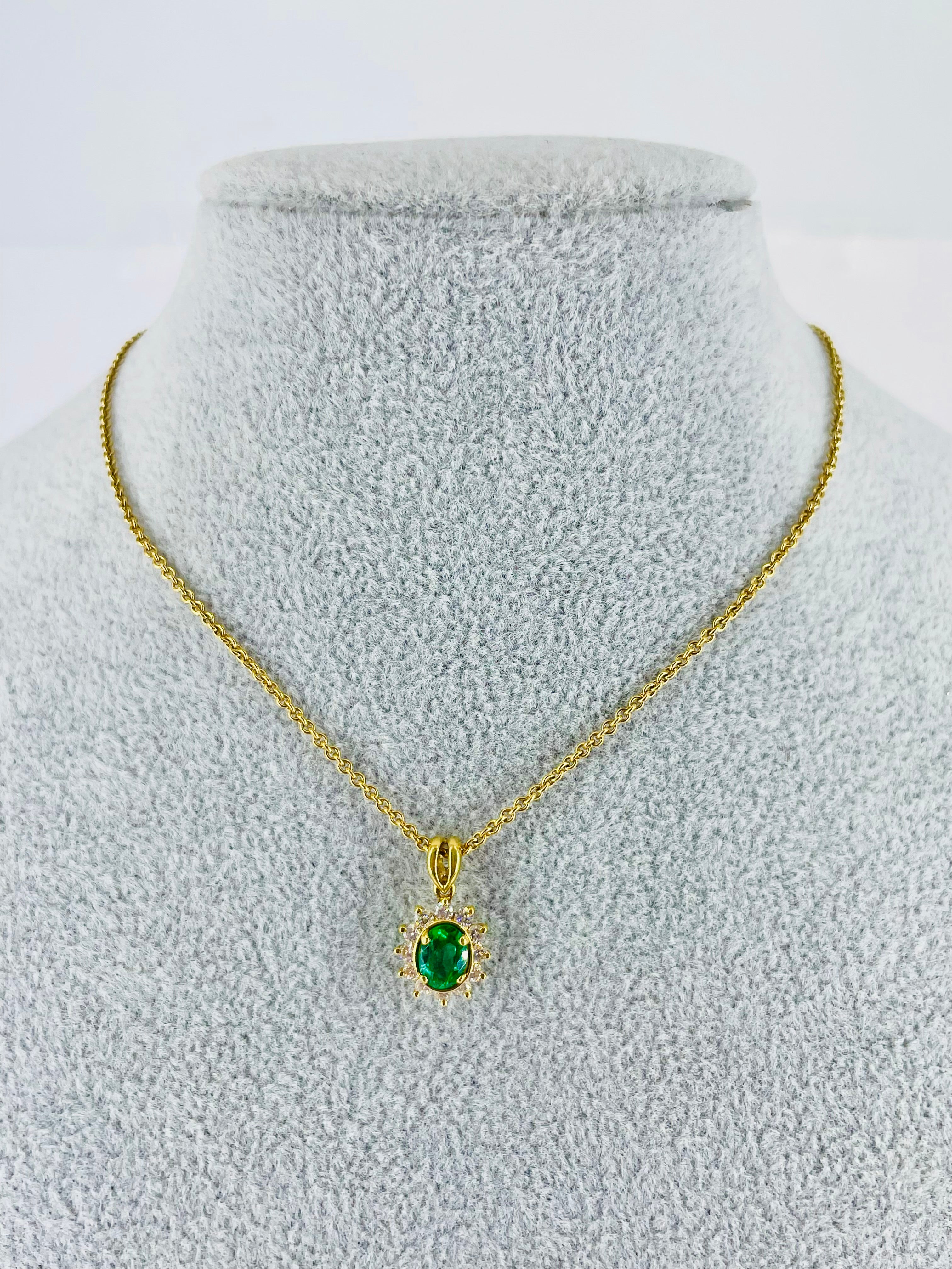 This beautiful pendant by Kurt Wayne features a rich green 0.56 carat oval shaped emerald. The center gemstone is framed by 0.35 carats of round diamonds. The decadent green is the perfect combination with the 18K yellow gold setting and chain. The
