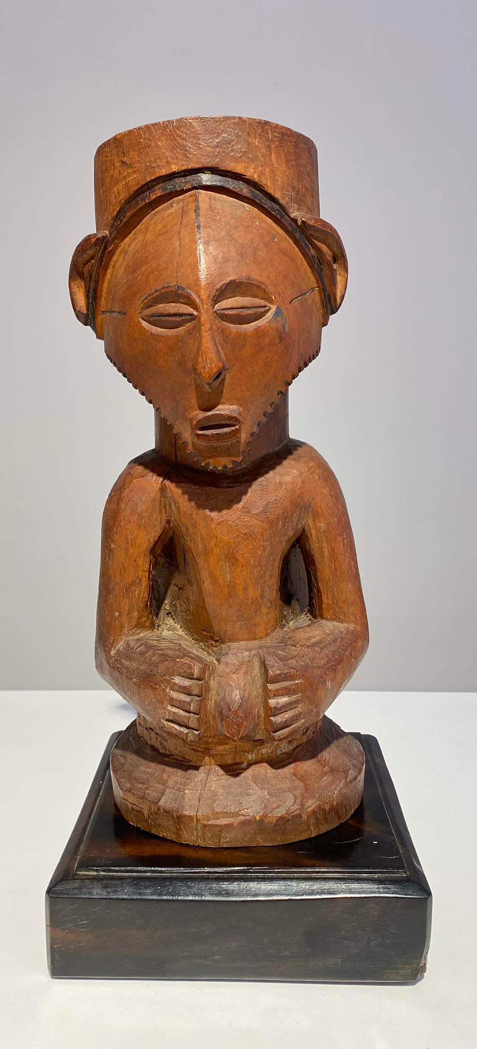 Nicely carved Kusu / Congo statue with beautiful face / almond shaped eyes and triangular face with beard. Top of the head is a big hole to charche the powerful statue and has patina of age and use. 
This statue, used for worship, is most likely a