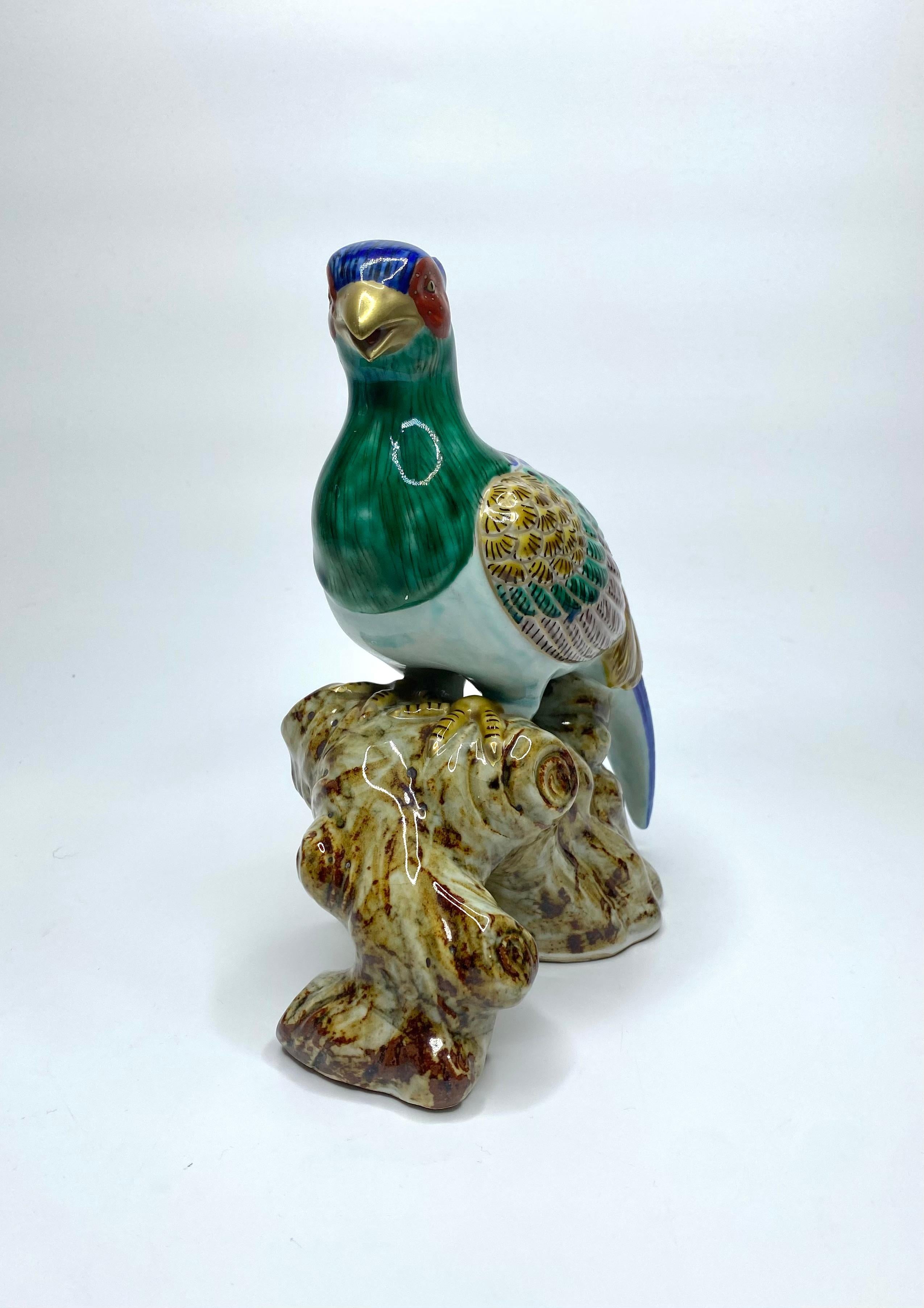 Kutani porcelain okimono of a Japanese Green Pheasant, Japan, Meiji Period. The pheasant modelled, perched upon a large gnarled branch.
Decorated in typically vibrant enamels, and heightened in gilt.
Height – 20.3 cm, 8”.
Width – 17.5 cm, 6