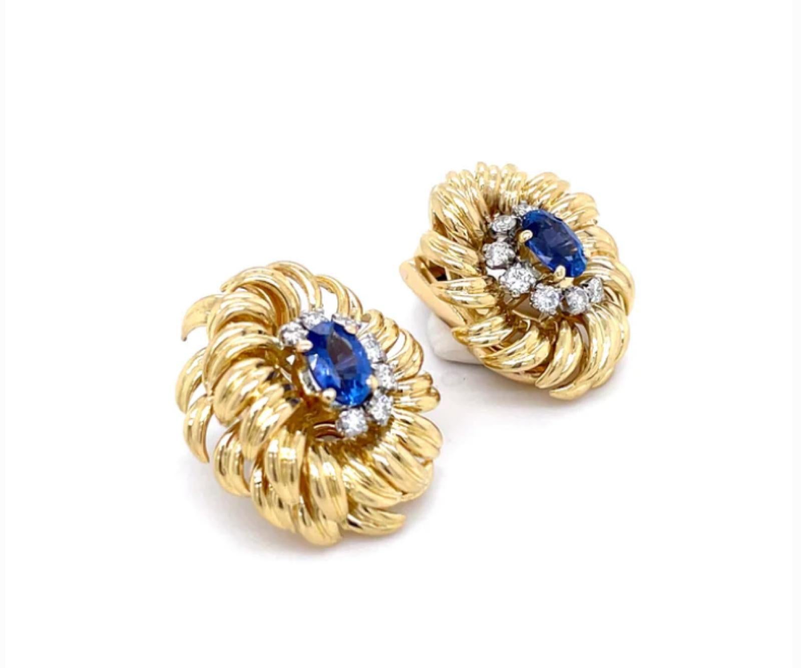 A pair of Kutchinsky 18 karat yellow gold sapphire and diamond clip earrings

A fantastic statement pair of earrings, each designed as a floral cluster, the leaves of plain polished gold are set to their centre with an oval cut sapphire for a total