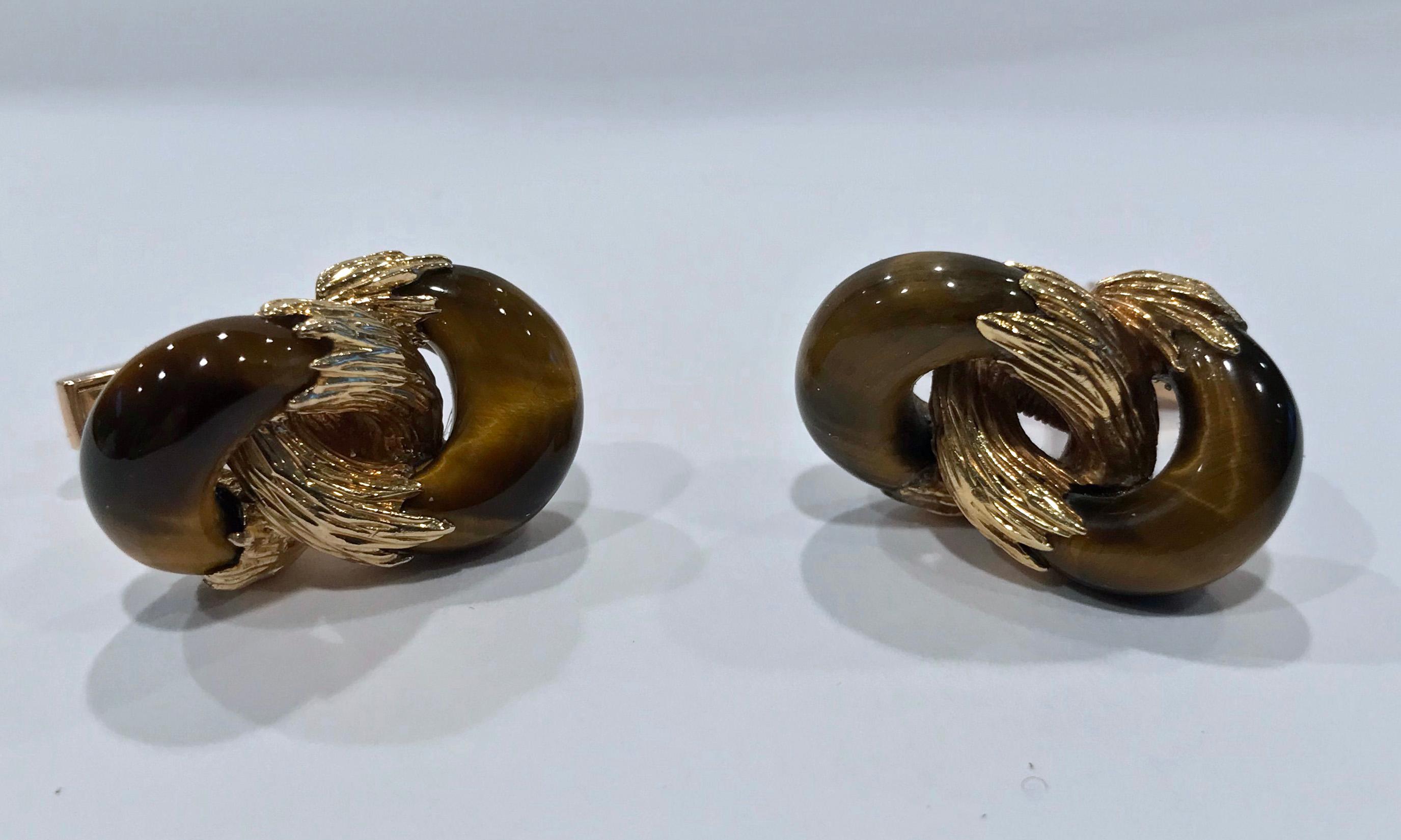 Kutchinsky Gold tigers eye Cufflinks, each cufflink comprising two interlocking loops of carved tigers eye with central textured gold feature to swivel T-bar fittings in 18ct gold. Full 18K hallmarks for London 1973 and signed both on reverse and