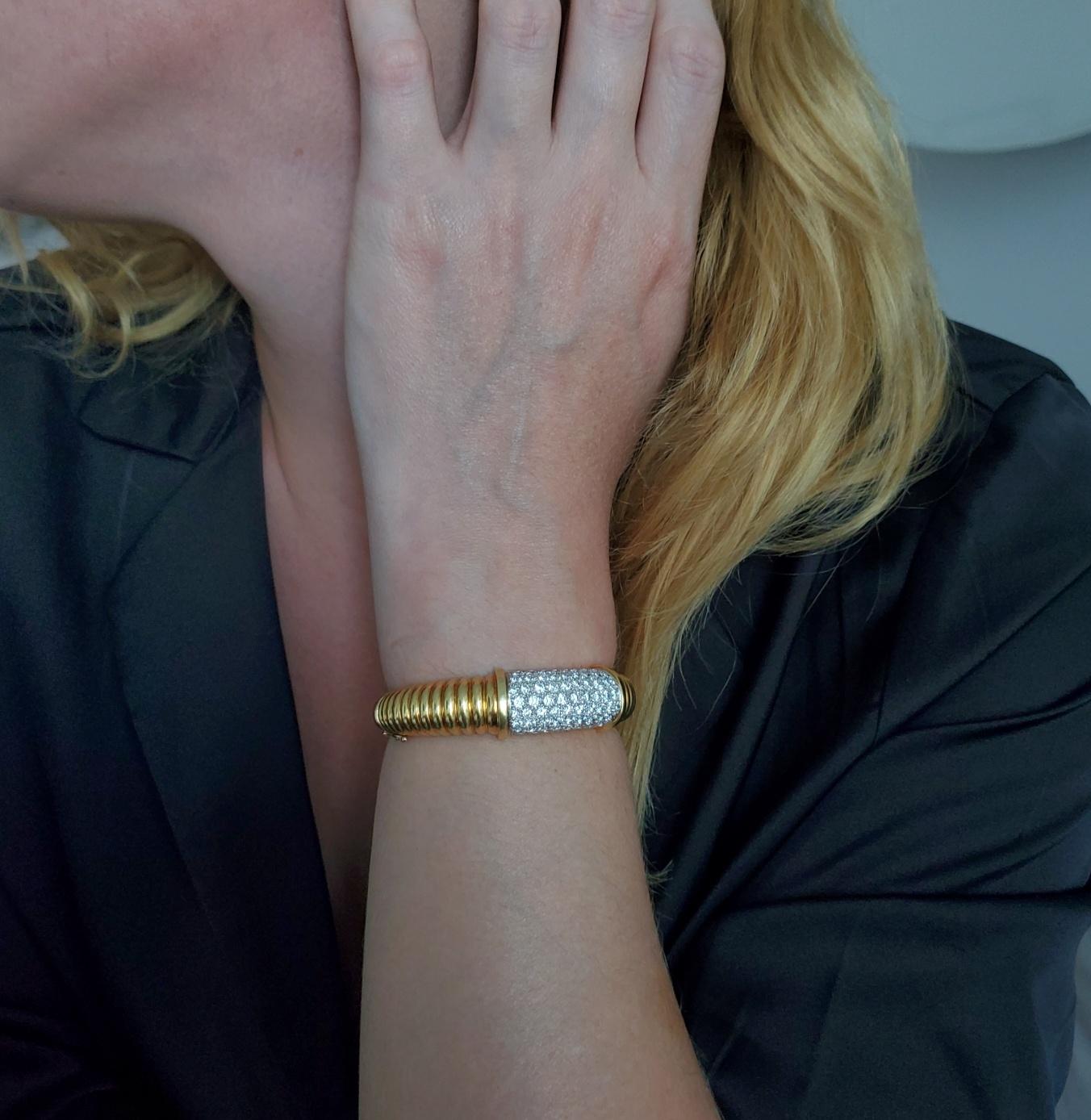 A bangle with diamonds designed by Kutchinsky.

Gorgeous modernism bracelet, created in London England by the jewelry house of Kutchinsky, back in the 1972. The main body is crafted with scalloped fluted patterns in solid yellow gold of 18 karats