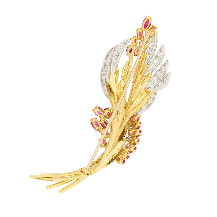 This gorgeous diamond & ruby brooch was hallmarked in the year 1965 and was created by the designer, Kutchinsky. The flowing gold design is accented by the elongated marquise cut rubies which add to the sense of movement in the piece. The rubies
