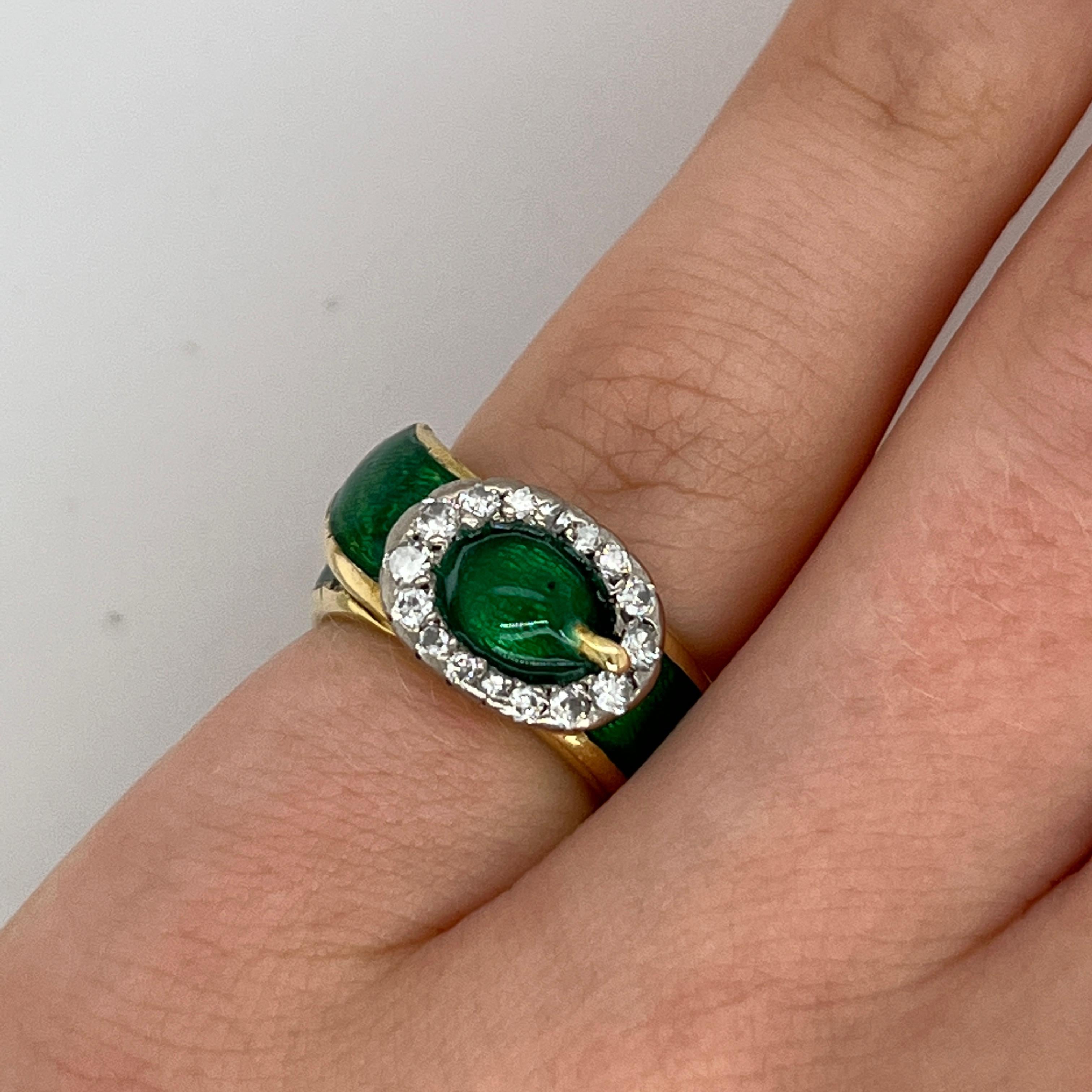 A striking and rare piece from the iconic British jeweller Kutchinsky, 
this buckle ring is beautifully crafted in 18ct yellow gold, 
accented with vivid green enamel and set with sparkling natural diamonds. 
The bold buckle motif, a signature of