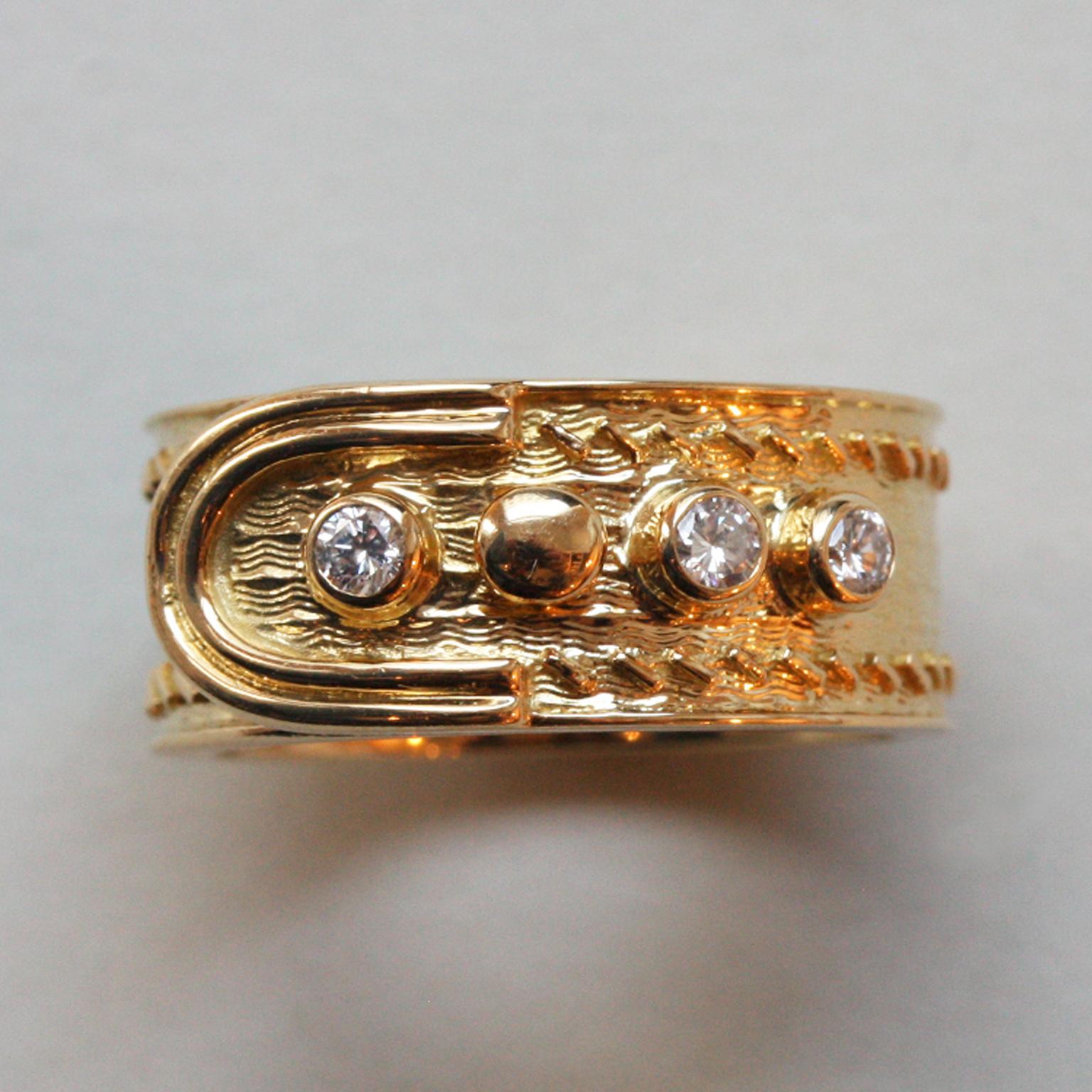 An 18 carat gold buckle ring with diamonds, the band or the belt has been decorated with a pretty  geometrical  and wave pattern with a smooth edge, it has four buttons of which three are set with a brilliant cut diamond (app. 0.1 carat), signed: