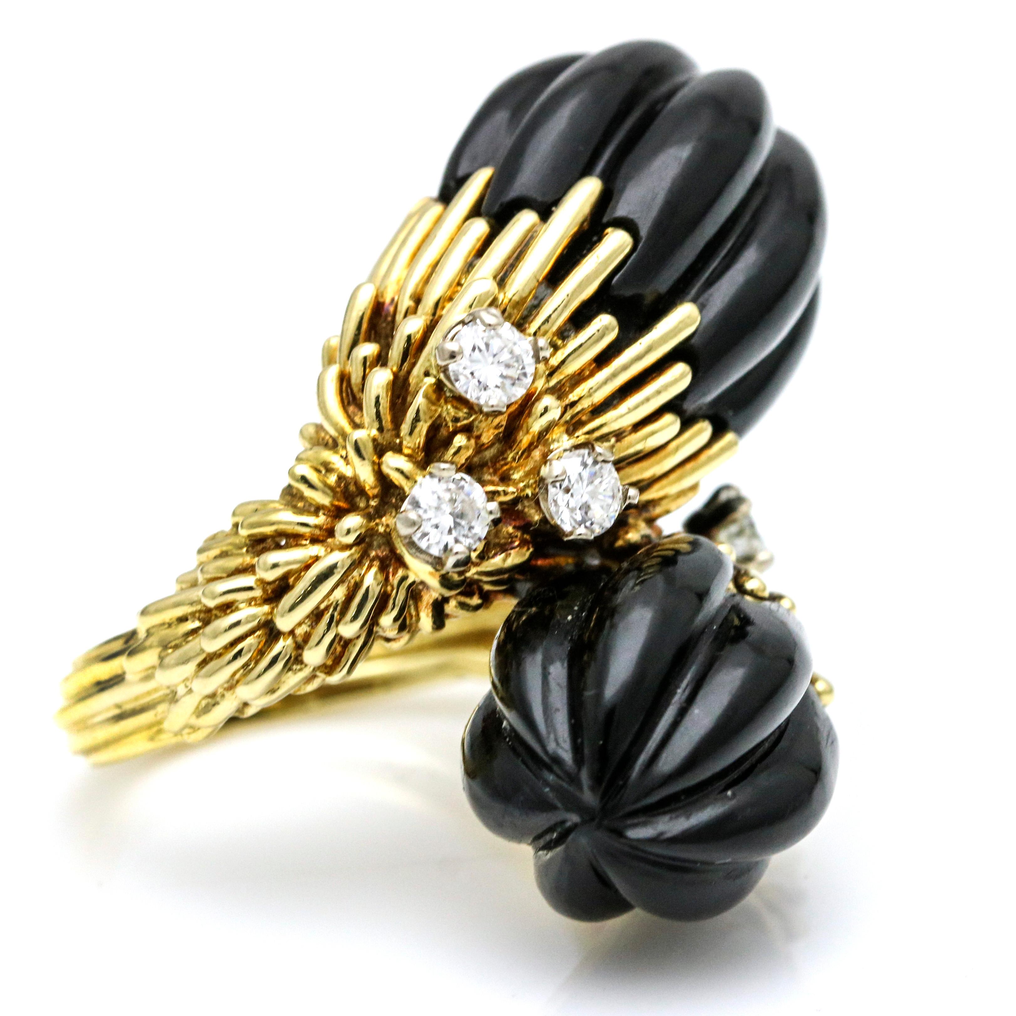 1970s Kutchinsky bypass ring in 18 karat yellow gold with carved onyx and diamonds. Size 6. The ring is prong set with 6 round diamonds. Weight, 18.6 grams. Height from finger, 21mm. Length, 32.5mm. Circa 1970s.
