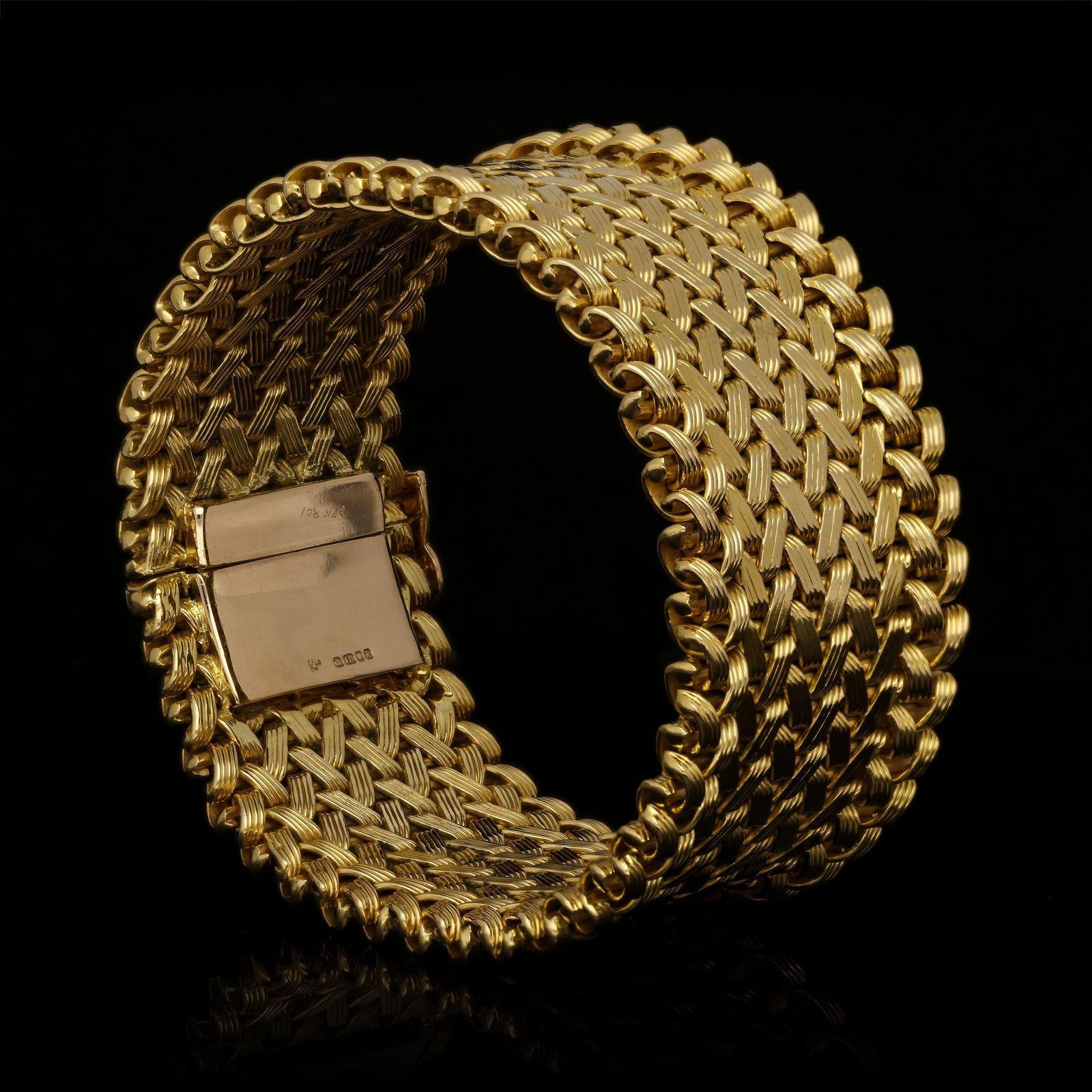 A stylish 18ct yellow gold bracelet by Kutchinsky 1966, the bracelet of wide strap design, formed of six rows of woven flattened gold strands in a repeating chevron pattern, edged with a double row of gold loops, to a concealed tongue and box clasp.