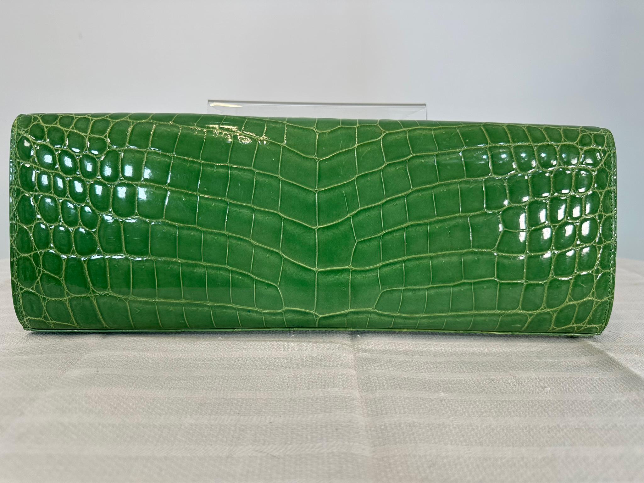Kwanpen grass green crocodile long clutch handbag with gold hardware. Rare spring/grass green crocodile clutch handbag, with a flap front closure and a tiny gold clasp. The bag is lined in matching textured leather and green soft leather. There is a