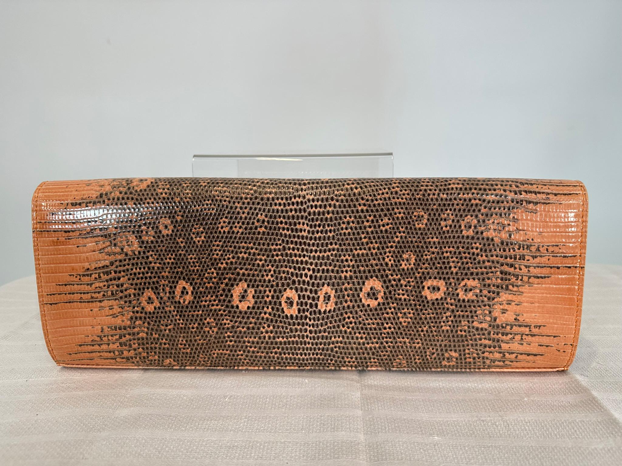 Kwanpen peach & black long lizard clutch handbag
with gold clasp. Flap front bag is long and elegant and easy to carry. Fully lined in bitter orange textured leather and tan textured leather. There is a single zipper compartment at the back side &