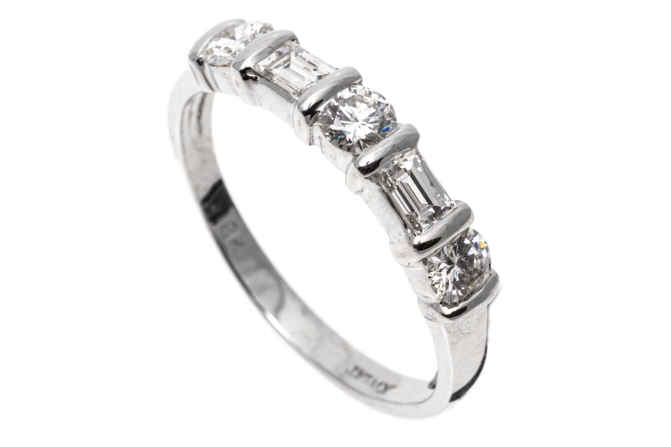 18k white gold ring. This gorgeous five stone, bar set band ring is set with three round brilliant cut diamonds, approximately 0.48 TCW, alternating with two large baguette cut diamonds, approximately 0.20 TCW, and finished with a high polished