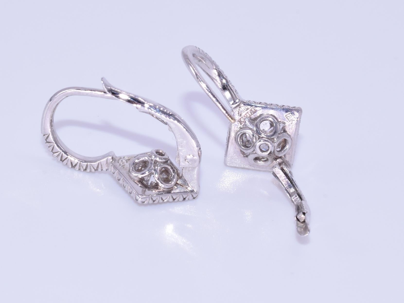 18k White gold Diamond Drop Earrings, Signed Kwiat

These diamond earrings are from the Kwiat Silhouette Collection with two princess cut and 54 round brilliant diamonds totaling 1.69 carats, FG/SI mounted in 18k white gold.  The original retail was