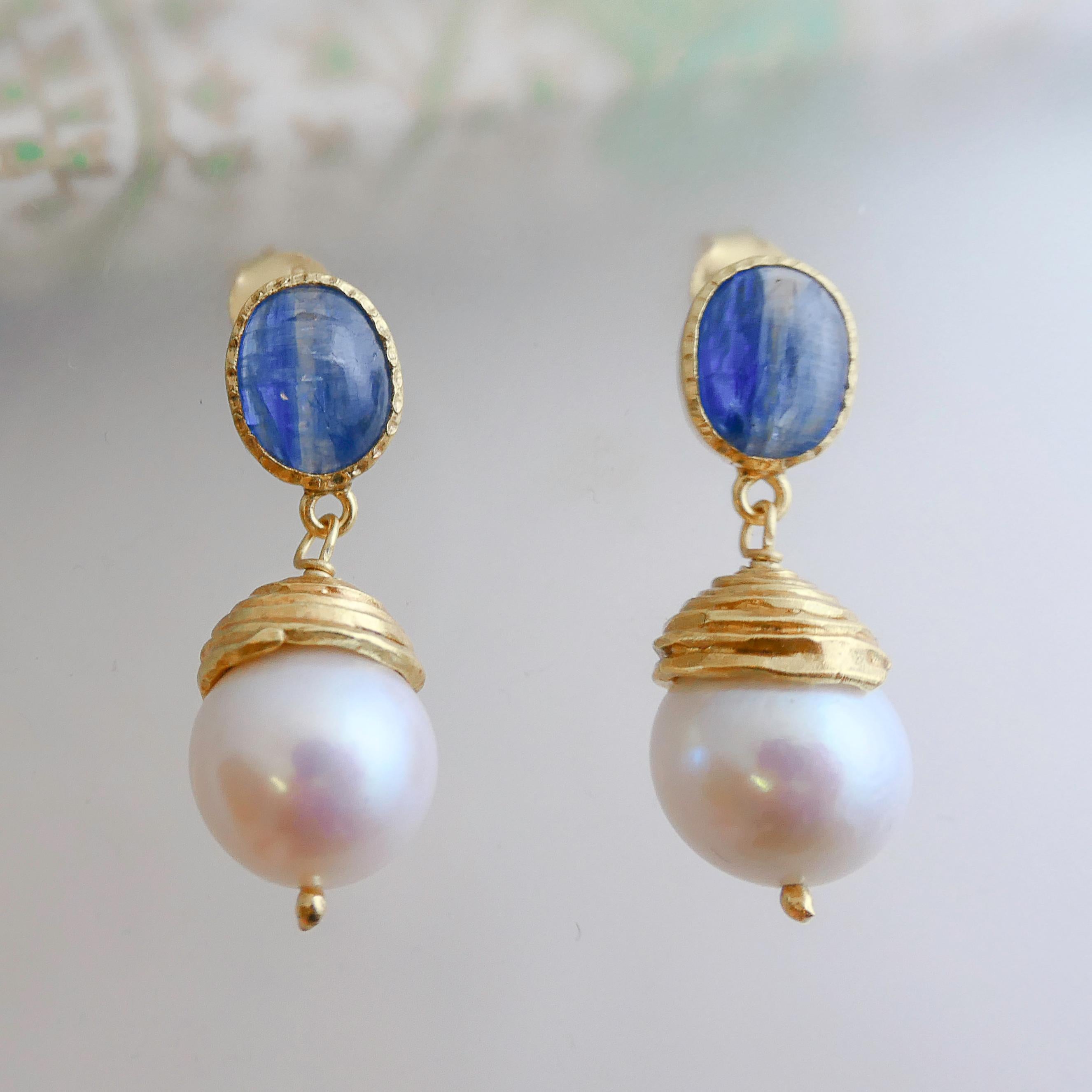 8 x 10 mm freeform Kyanite is set in gold-plated sterling silver. A 12mm freshwater pearl is wrapped underneath the stud / post earrings. The length of the earrings is 3.1 cm