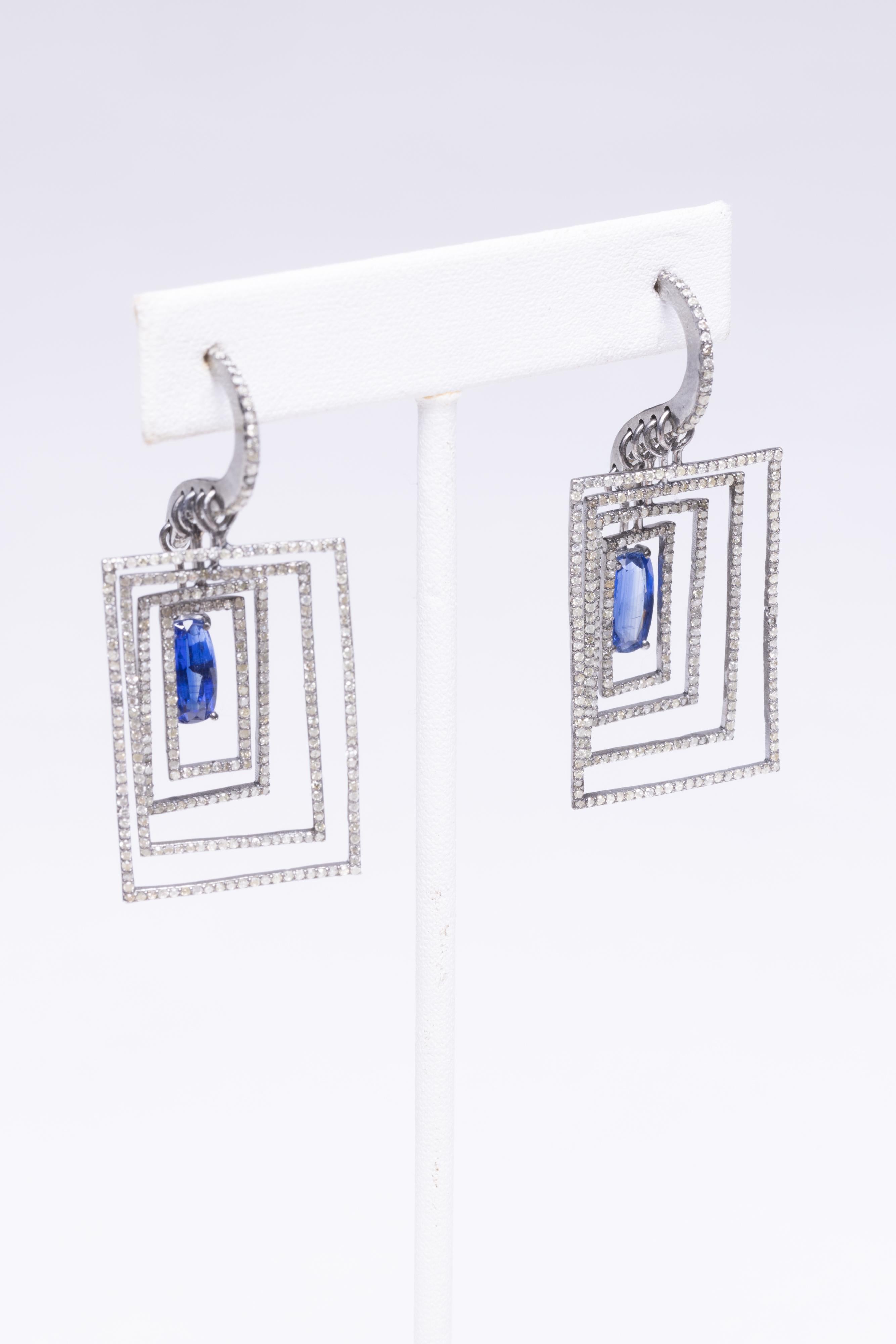 A very unusual pair of dimensional earrings.  A picture frame within a frame, within a frame, etc, and slightly recessed each time.  Oval faceted kyanite at the center of the smallest frame has pave` set, round brilliant cut diamonds. set in