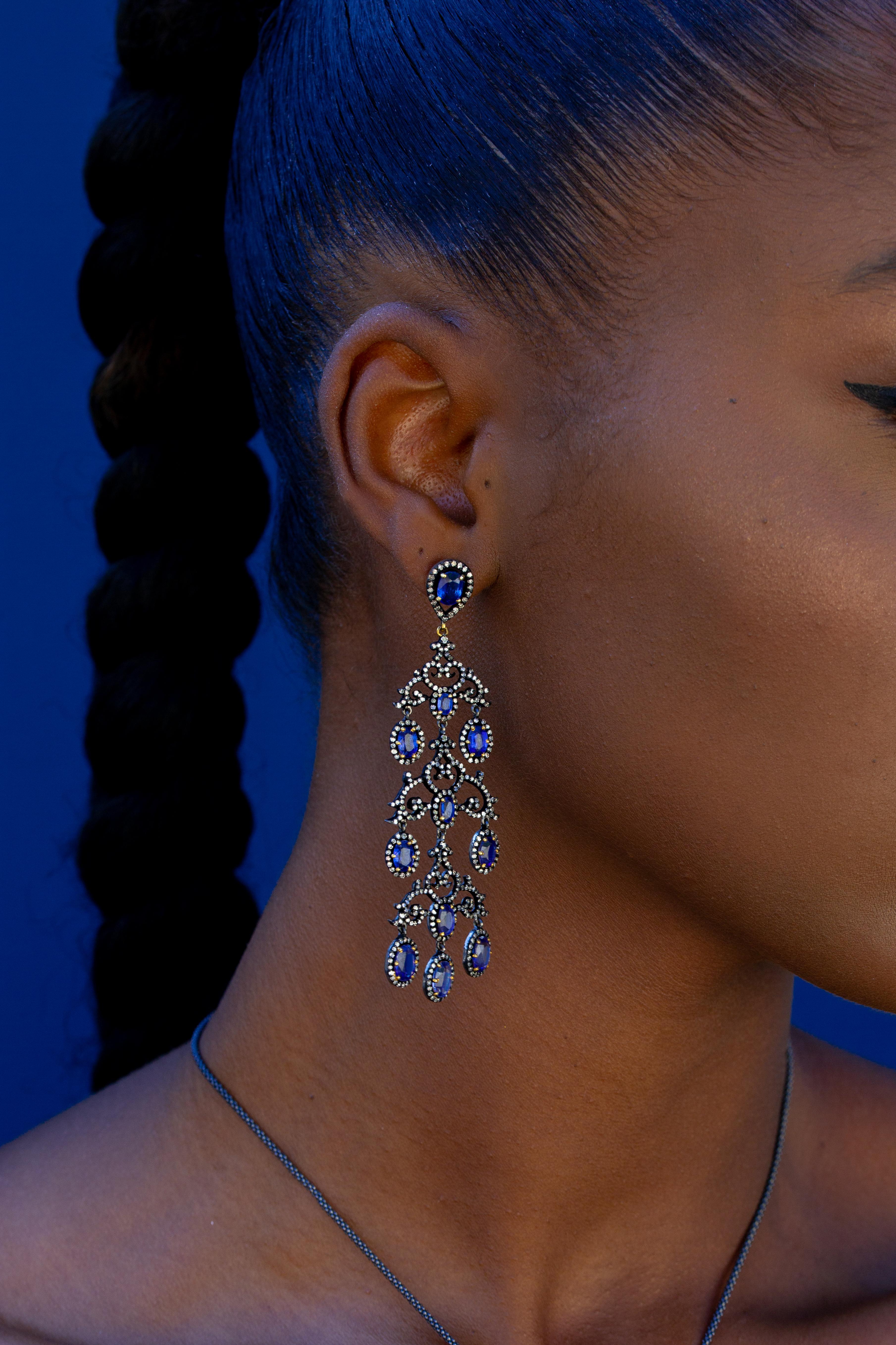 Evoking royalty, this chandelier style earring features Kyanites, accented with diamonds in oxidized silver. This exquisite jewelry piece adds a touch of sophistication and sparkle to any look. It's the perfect way to make a statement.