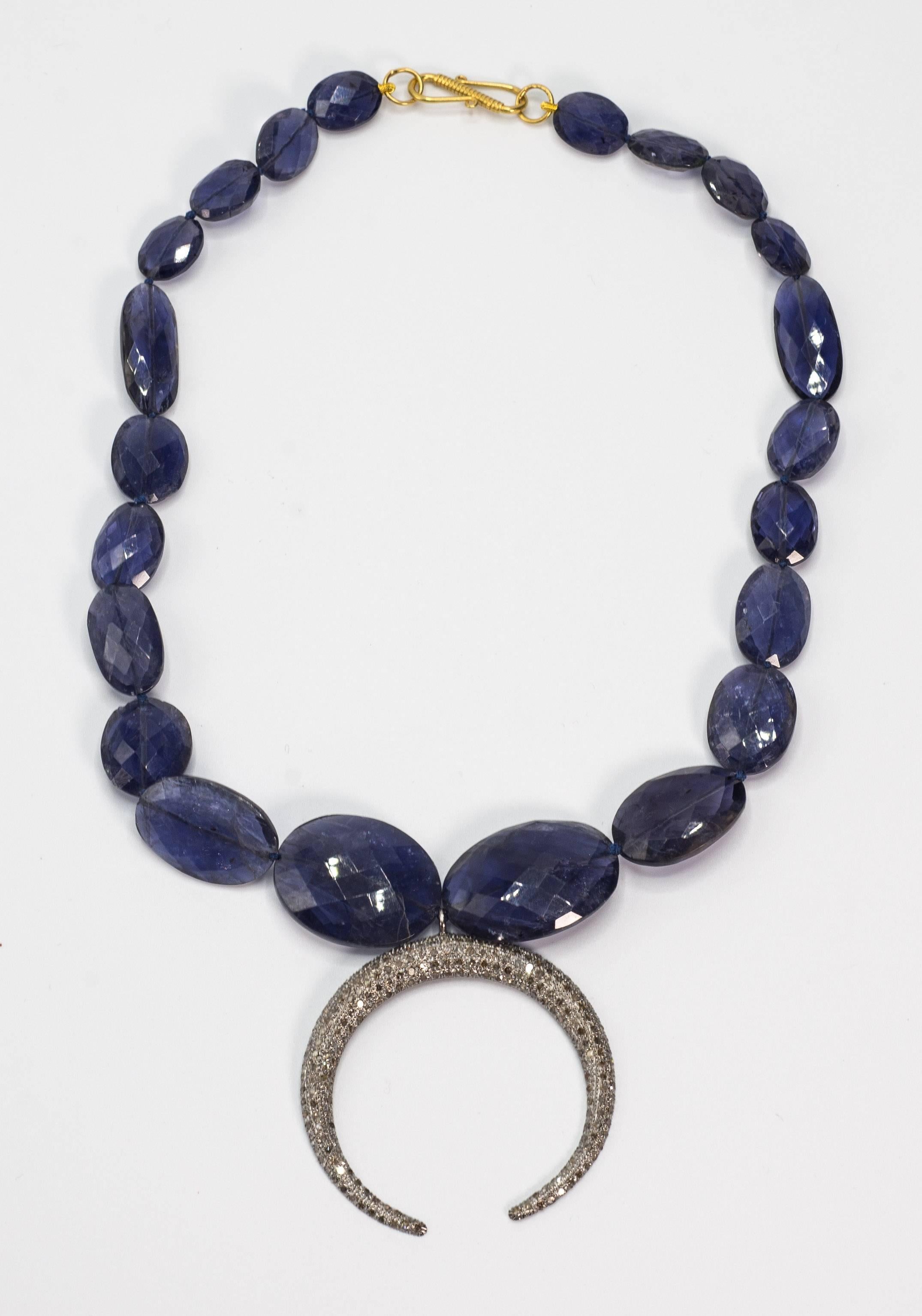 Blue Kyanite faceted beads weighing approximately 240 carats suspending a pave antique cut silver mounted crescent attached to a gold clasp.
The necklace is 16'' long and the crescent is 1/5 inches diameter.