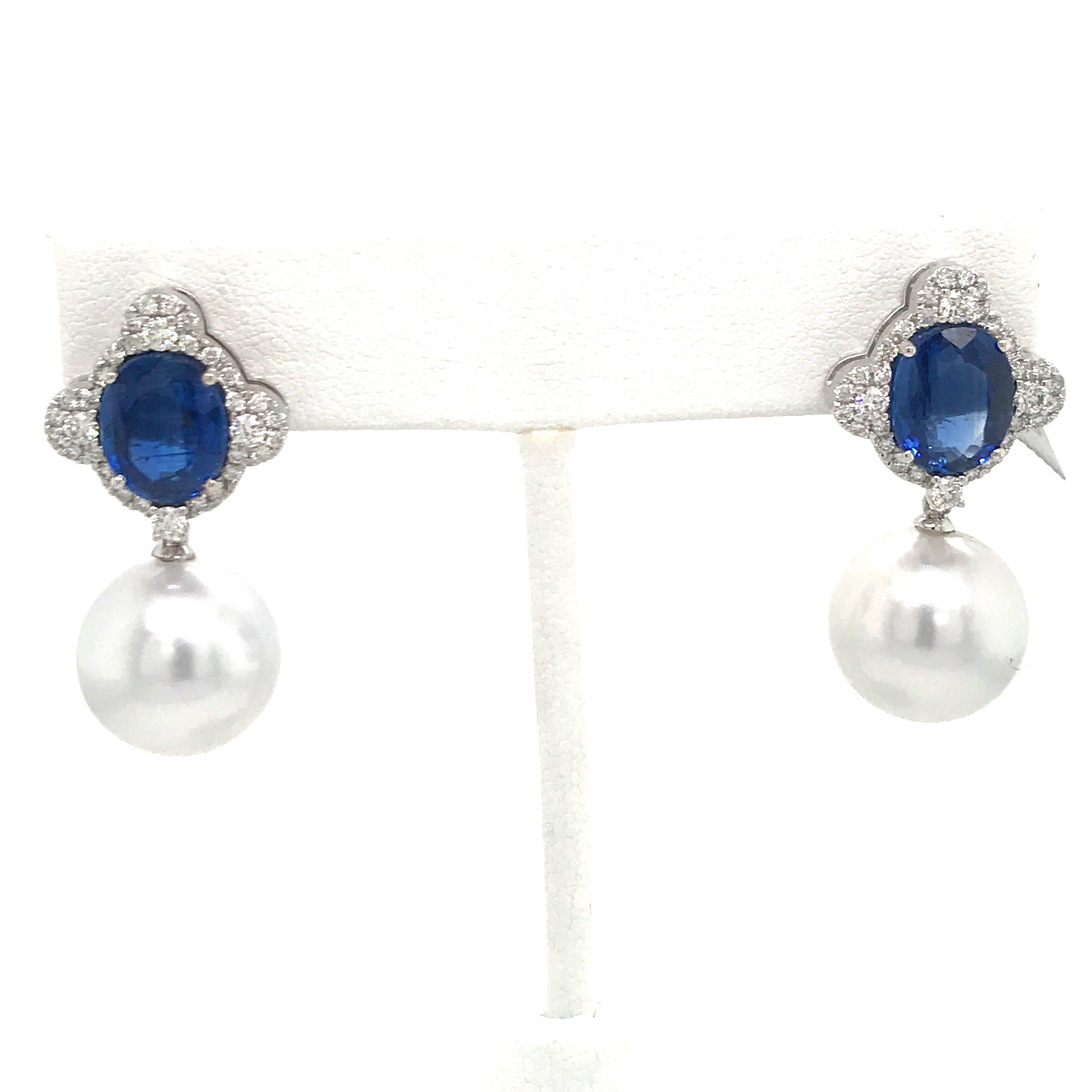 18K White gold earrings featuring two oval cut Kyanite weighing 6.50 carats flanked with 64 round diamonds, 0.75 carats with two South Sea Pearls measuring 13-14 mm.