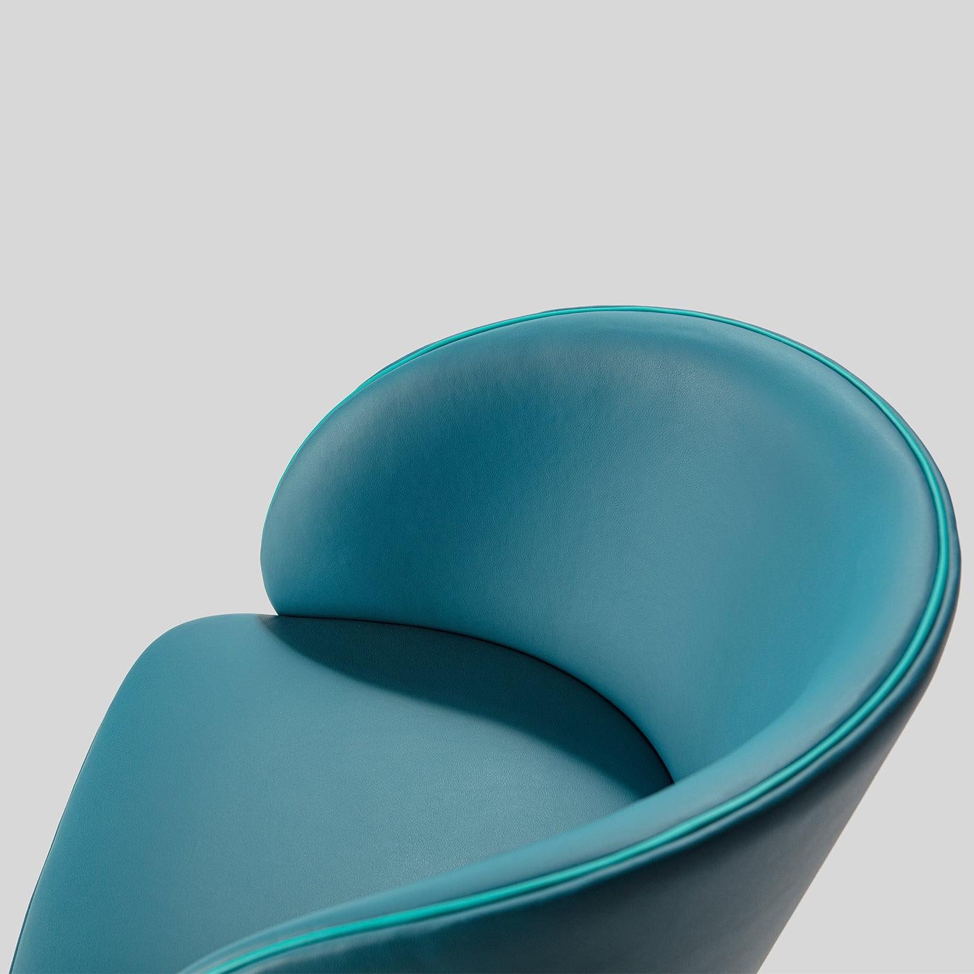 Part of the Kyoto Collection of chairs characterized by rounded and well-proportioned shapes. The beechwood frame boasts a nicely curved backrest and generous seat raised on long, tapered black-finished legs with low footrests. Wrapped in light blue