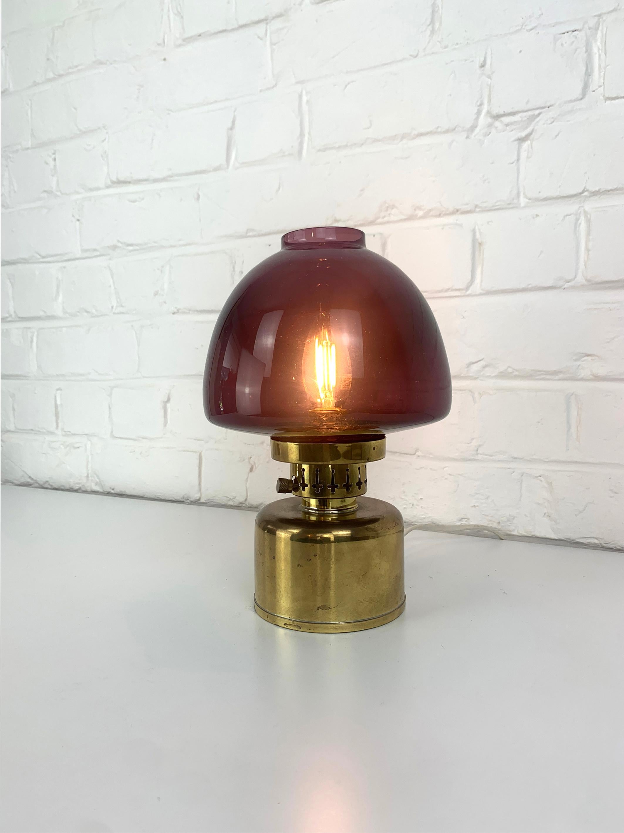 Swedish L/101 table lamp in brass. Design by Hans-Agne Jakobsson.

A nice example of Jakobsson's L-101 Model Lamp with its original purple glass shade. 

Manufactured by AB Markaryd in Sweden, retains the original manufacturer label.

This was