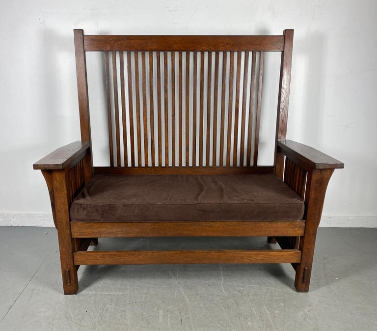 L and J.G. Stickley oak Arts & Crafts mission bench. Superior quality and construction with a solid oak frame and a loose cushioned seat. Measures: 51.75 W x 49 H x 22.5 D. Seat height 18.5 H (to top of seat cushion).Hand delivery avail to New York