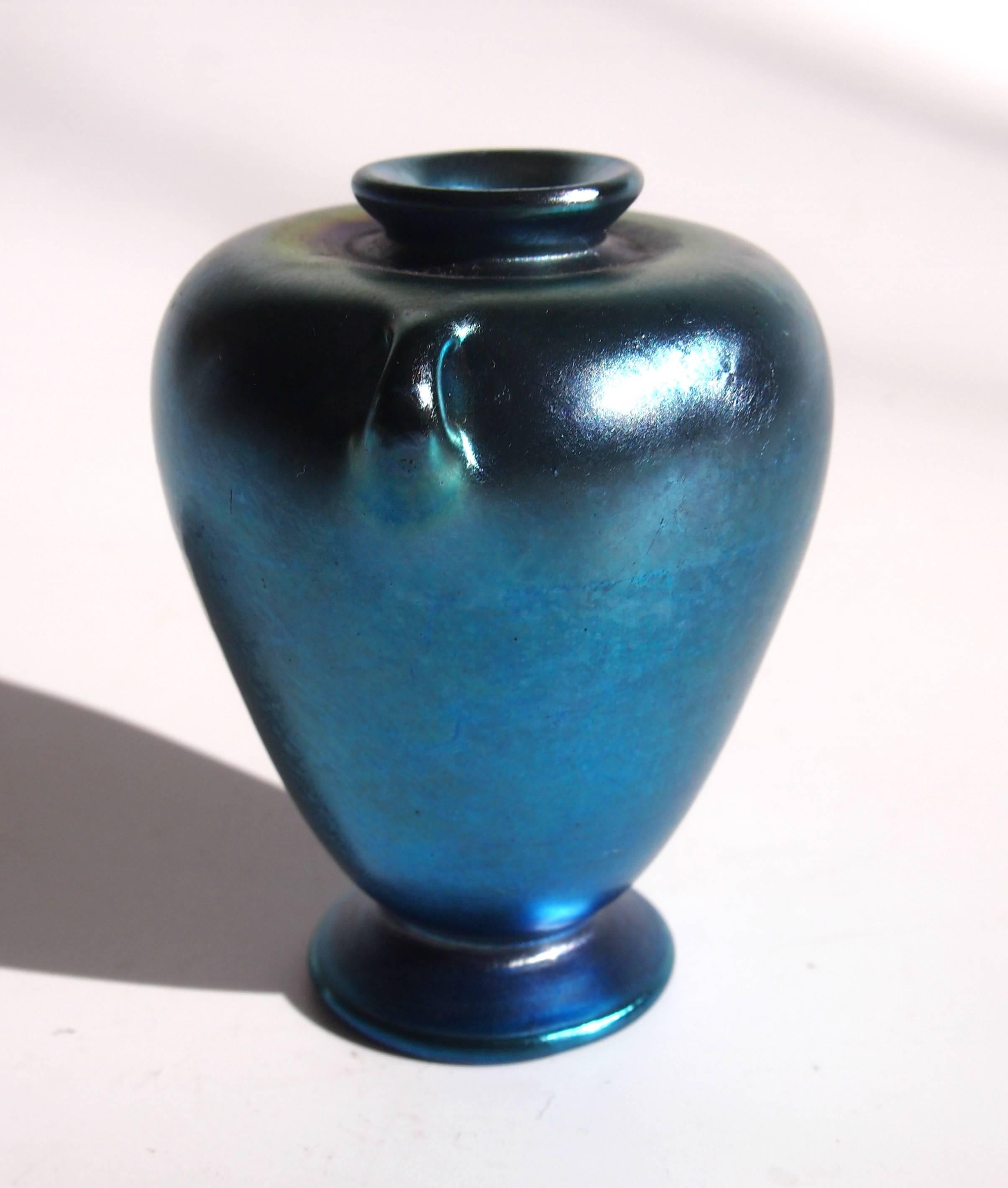 A very rare Art Nouveau Louis Comfort Tiffany blue Favrile miniature vase in the art nouveau style and shaped like a tiny footed Greek urn with two cute handles and narrow opening top. Beautifully signed 'L.C.Tiffany Inc Favrile' Then the date code