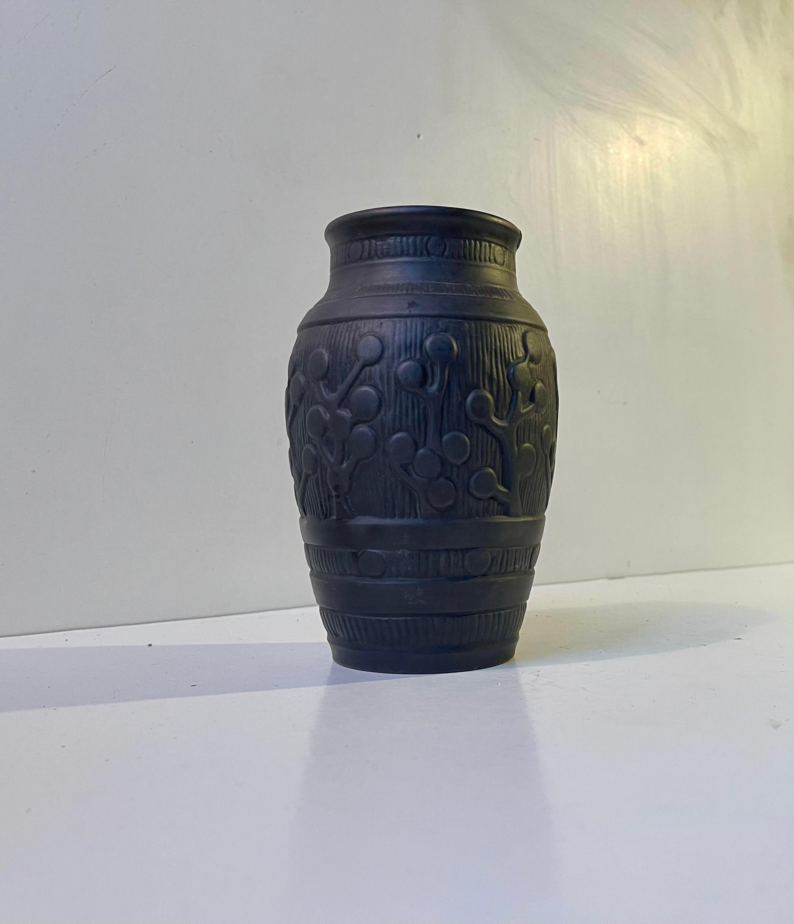 Number 747 relief vase in matte black glazed terracotta. Made during the 1890s on the Island of Bornholm by L. Hjorth possibly after a pattern by Thorvald Bindesbøll. 
Measurements: H: 16.5 cm, Diameter: 10/7 cm (middle/top). 
Please read the item