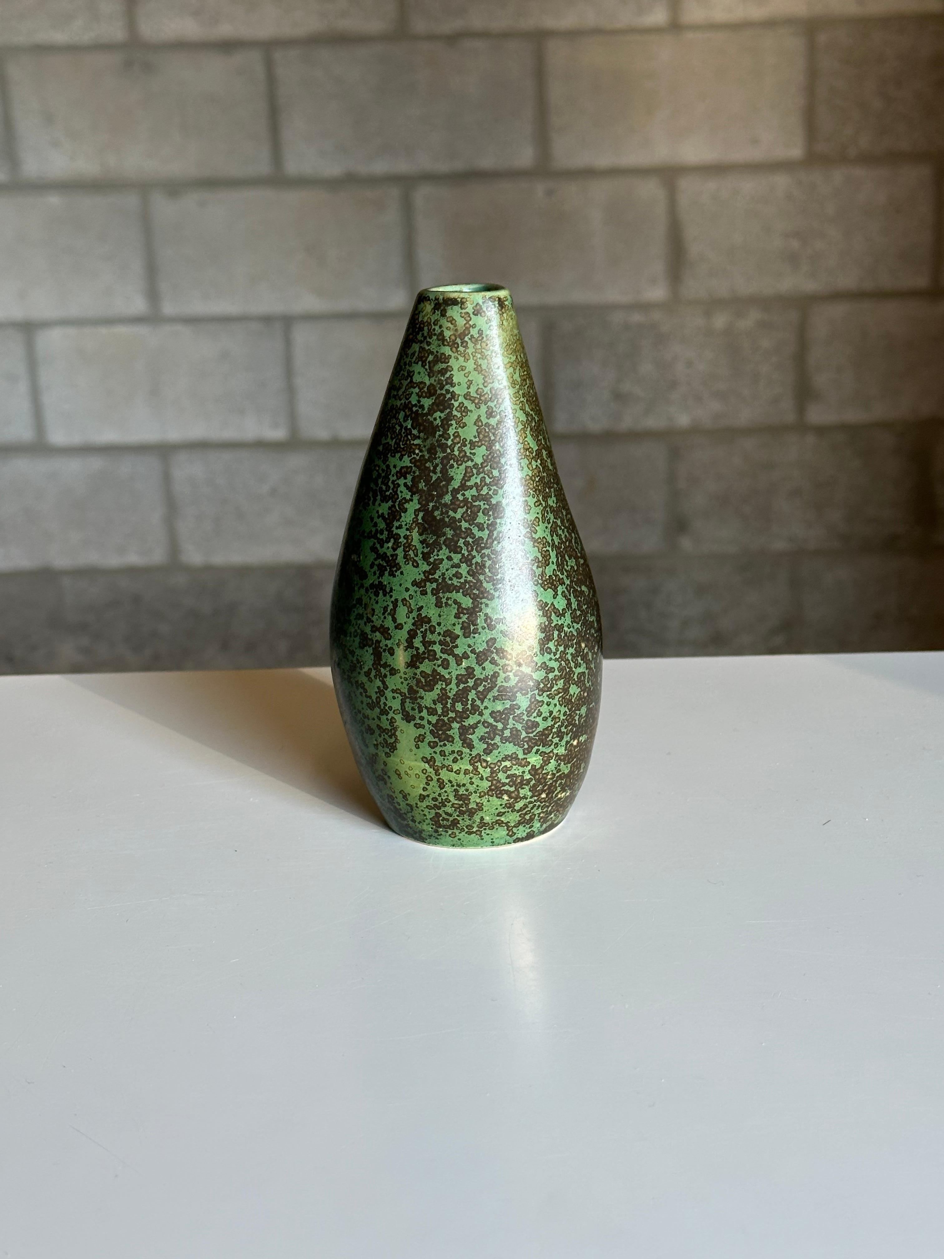 An unusual vase from L. Hjorth, produced in Denmark circa 1950s. Features a wonderful predominately green body with a dark overspray like glaze. Unique shape is rounded towards the bottom and slowly begins to change into a rounded triangle form near