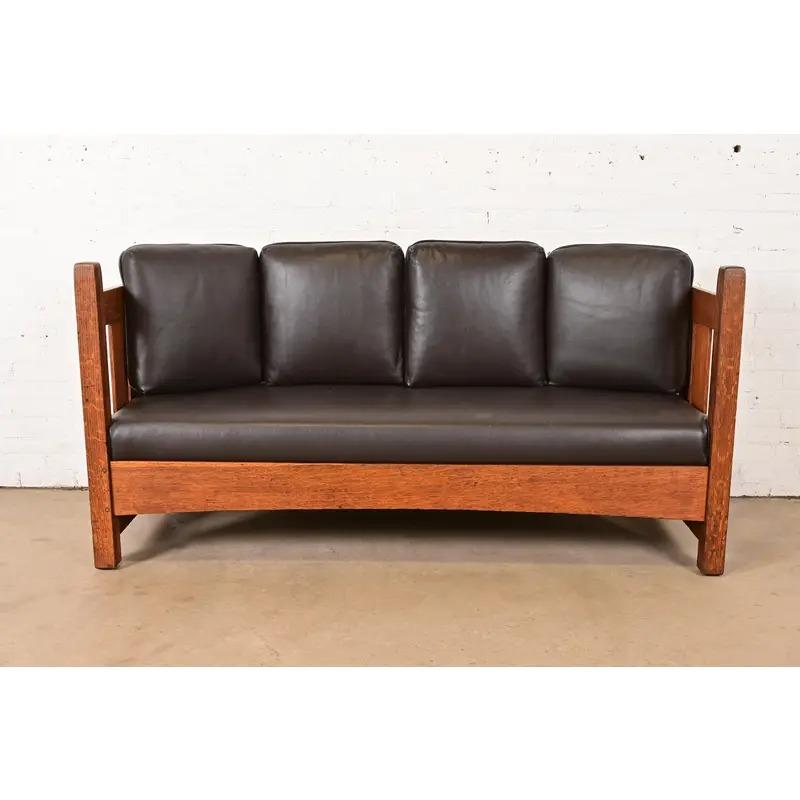 A beautiful antique Mission or Arts & Crafts period settle sofa

By L. & J.G Stickley

USA, Circa 1910

Quarter sawn oak, with brown leather upholstered seat and back cushions.

Measures: 72