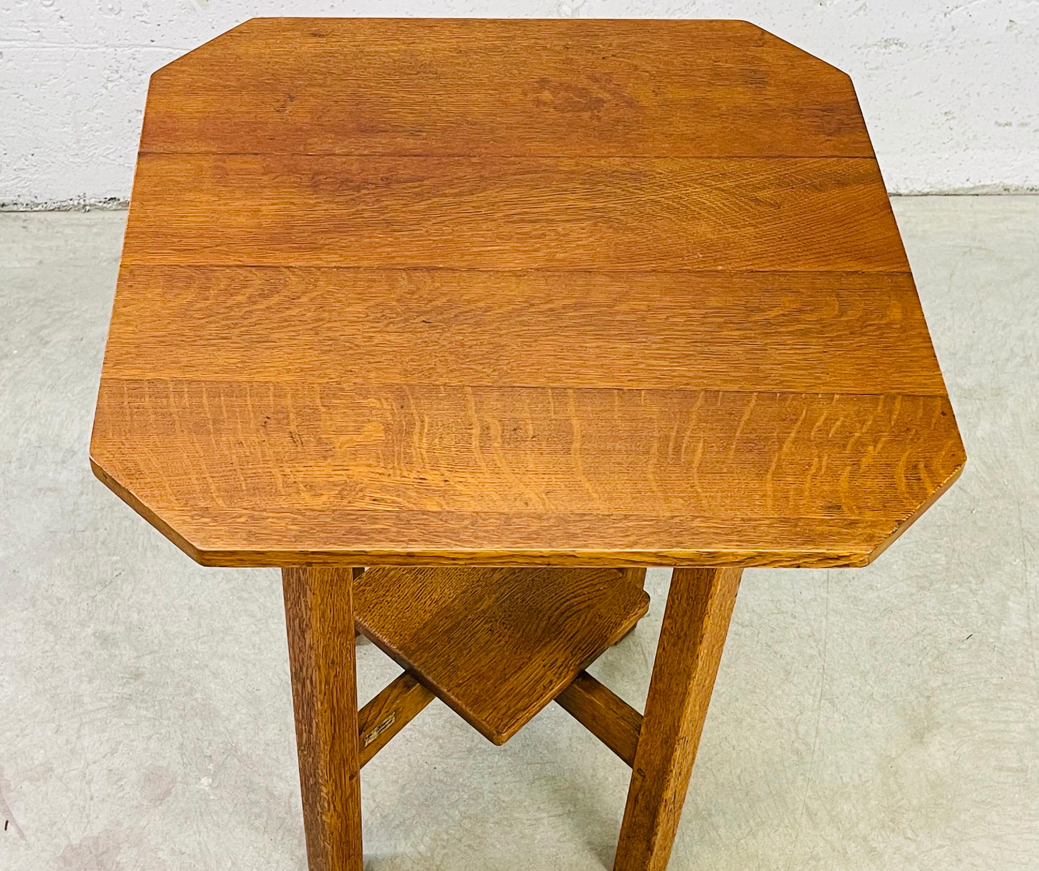 L. & J. G. Stickley quarter sawn oak square clip-corner lamp table circa 1910. The table has an additional shelf underneath for storage. This table has been carefully restored to the original condition retaining the original foil label.