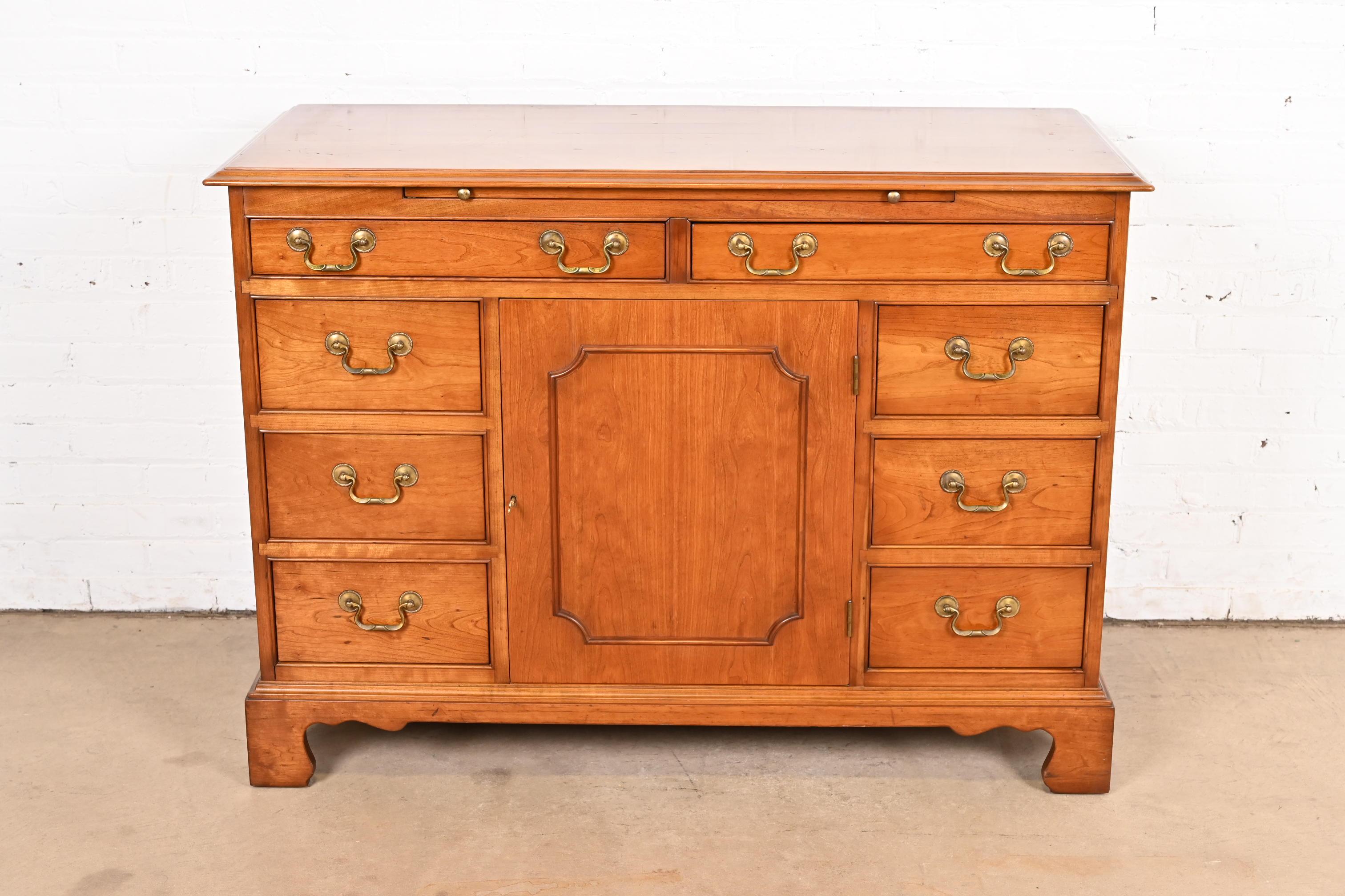 A gorgeous Georgian, American Chippendale, or Colonial style sideboard, buffet server, or bar cabinet

By L. & J.G. Stickley

USA, 1950s

Solid cherry wood, with original brass hardware. Cabinet locks, and key is included.

Measures: 48