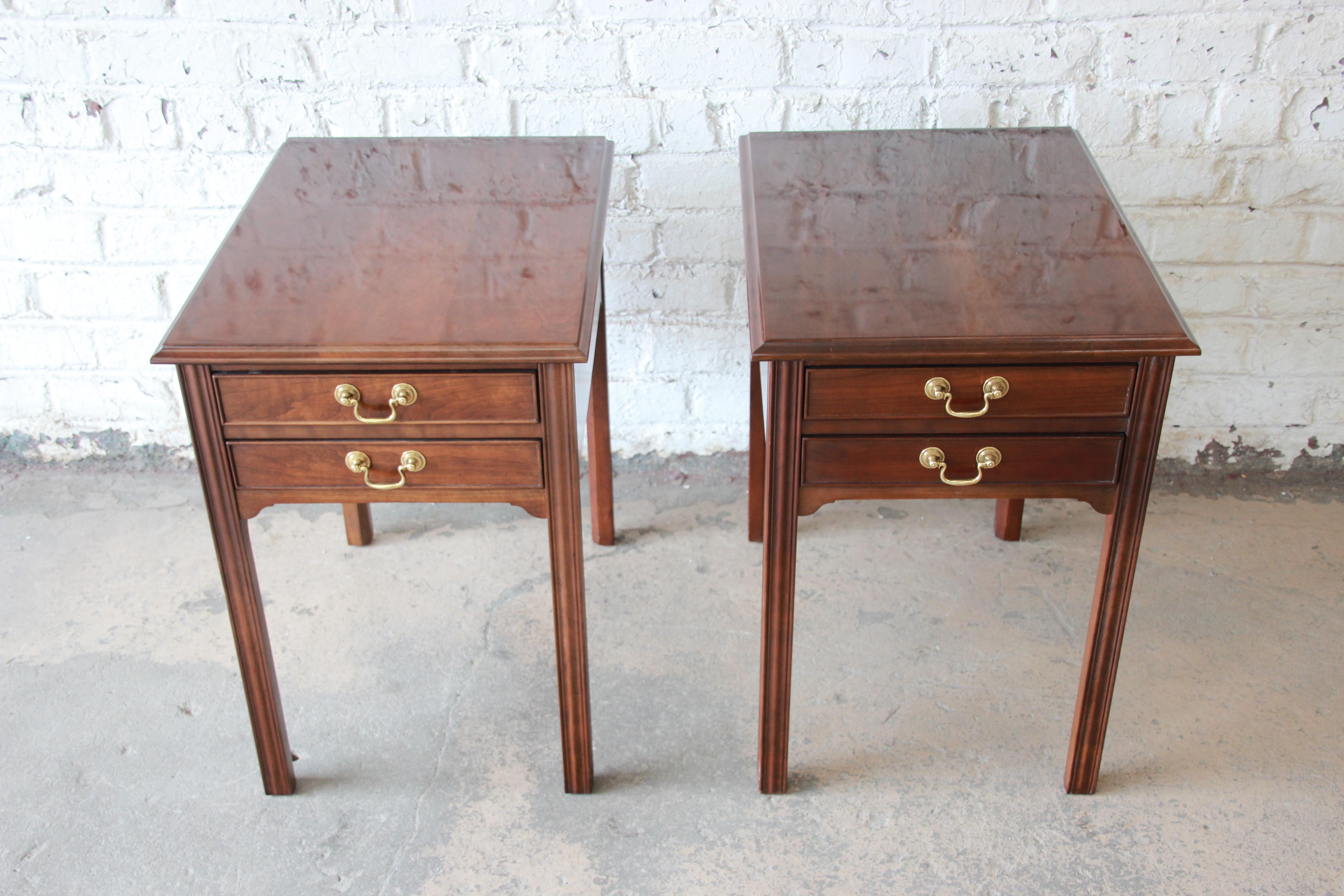 A gorgeous pair of solid cherrywood nightstands or side tables by L. & J. G. Stickley. The tables feature beautiful cherrywood grain and a nice traditional Georgian style. They offer good storage, each with two dovetailed drawers. The original