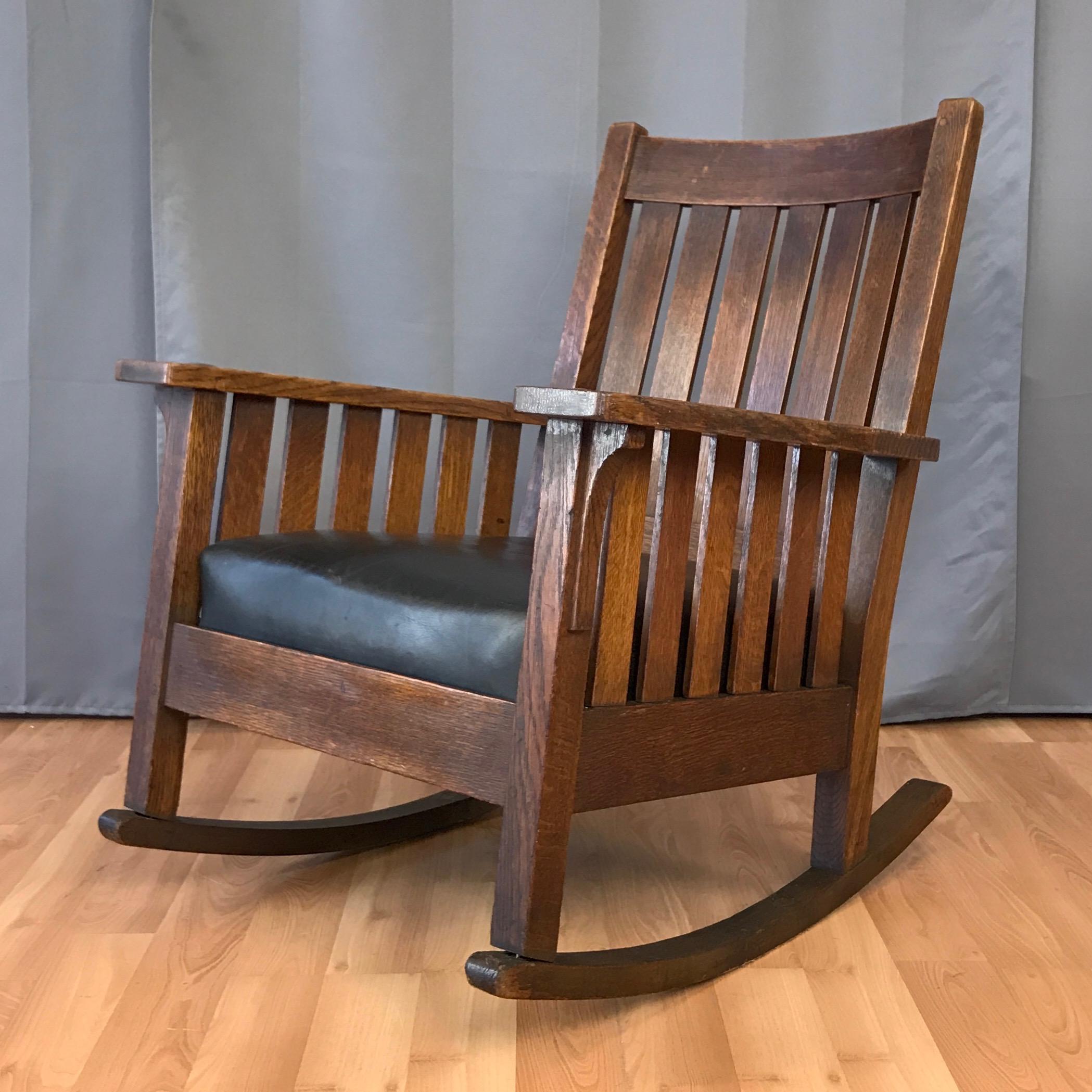 A 1920s L. & J.G. Stickley Arts & Crafts oak and leather rocker with original label.

Early 20th century American classic in quarter sawn oak with vertical slat sides and back. Original finish with natural patina and light wear exudes handsome