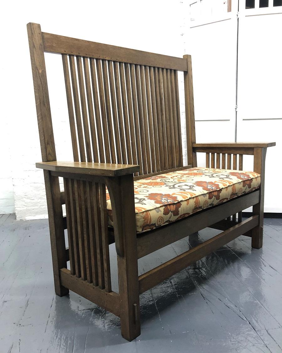 L and J.G. Stickley oak Arts and Crafts mission bench. The bench is well constructed with a solid oak frame and a loose cushioned seat.
Measures: 52 W x 49H x 23D.
Seat height 19H (to top of seat cushion).

