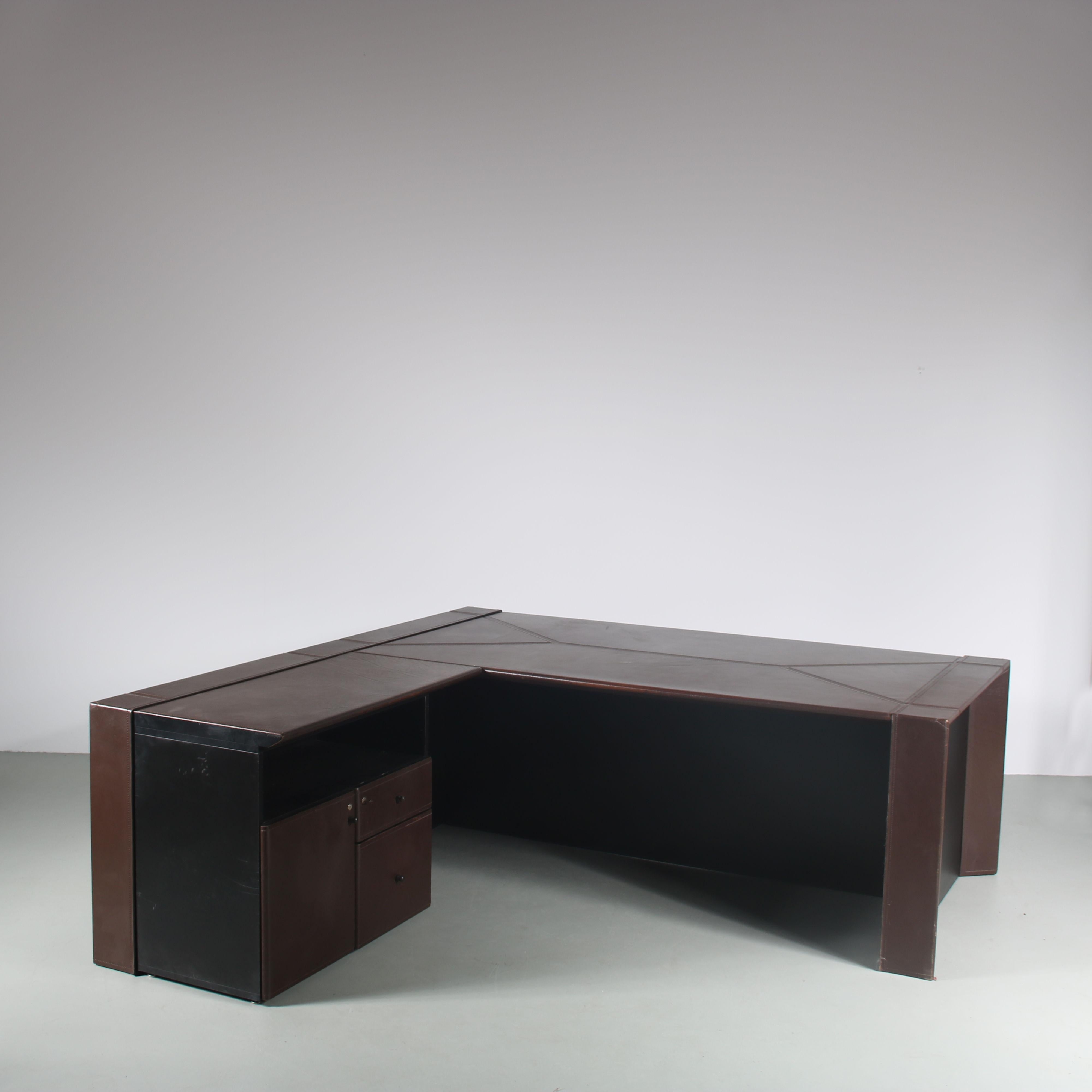 A beautiful executive desk designed by Guido Faleschini, manufactured by Mariani in Italy around 1970.

This eye-catching desk has an L-shaped design and a very impressive appearance because of it’s large size and leather upholstery. One side is