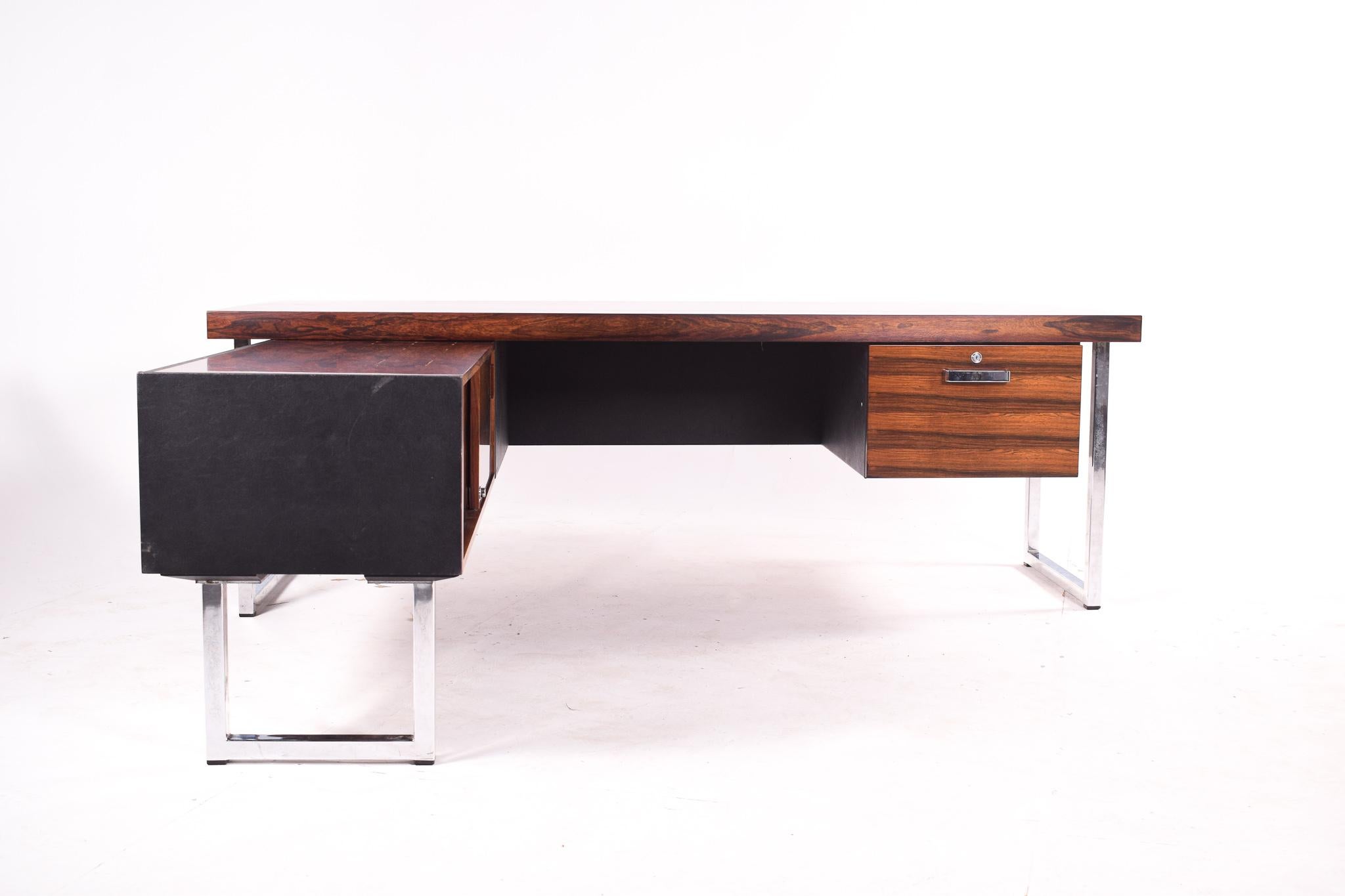 L-shaped desk designed by Gordon Russell for Gordon Russell ltd. The desk is completely original and restored. With two parts (sideboard and desk). The side of the sideboard has two slide doors. Made of rosewood veneer. Legs and handles in metal. An