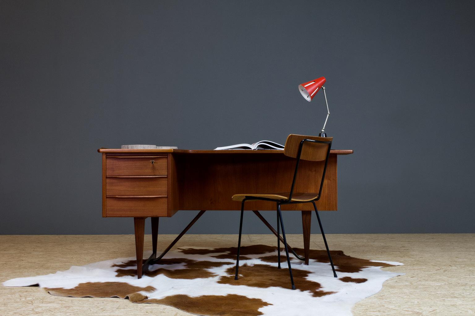 Elegant Scandinavian Modern freestanding desk in solid teak designed in 1956 by Peter Løvig Nielsen, Lovig Brand present. The desk has an extra storage compartment in the back, with a small liquor space with decorated mirror in the back, which all