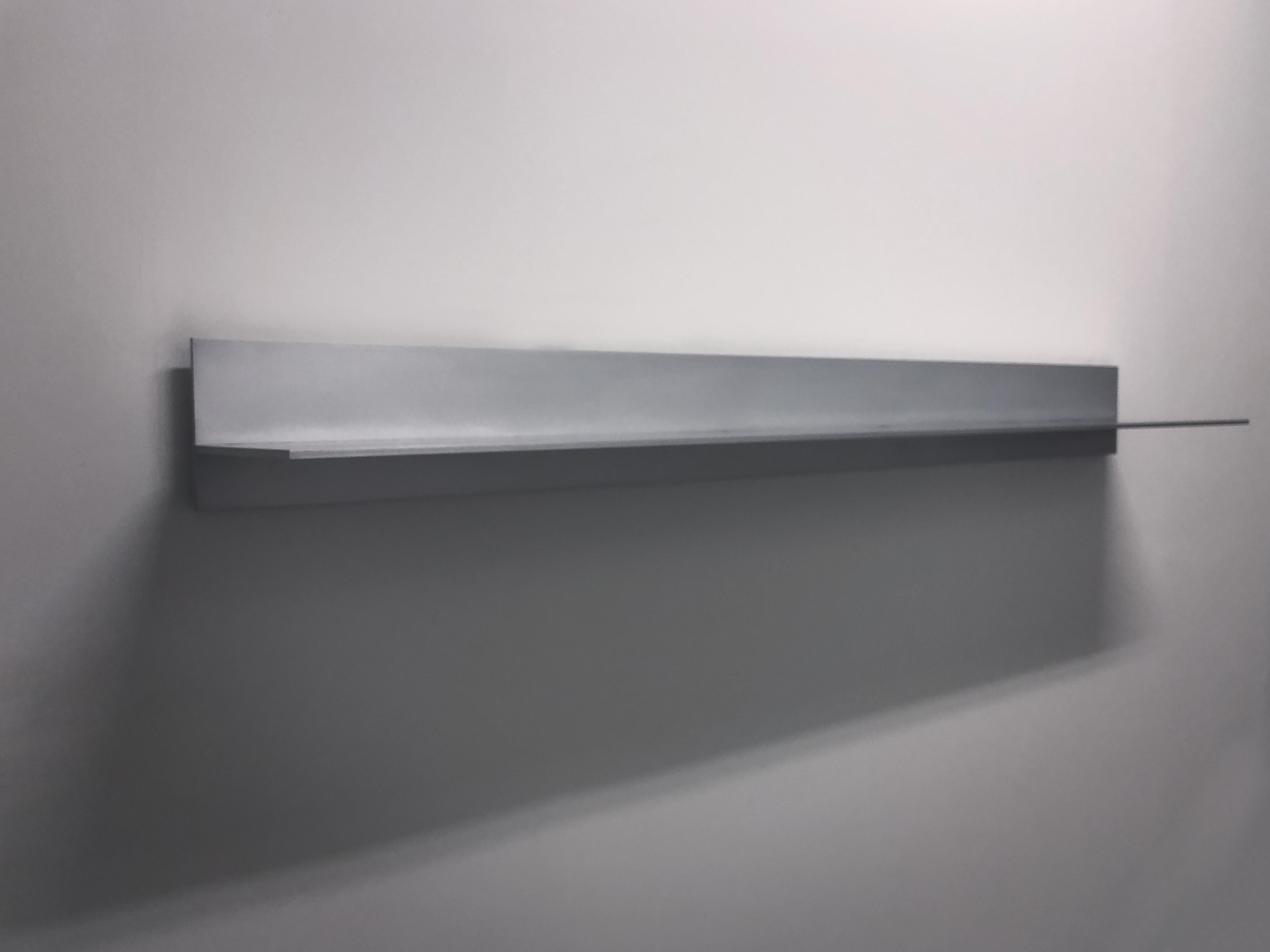 L-wall shelf in .25 inch thick aluminum plate. Digitally cut aluminum plates intersect and are fused with recessed welds that are ground smooth. Plates are hand finished and waxed. Included are two custom, steel wall cleats with instructions for
