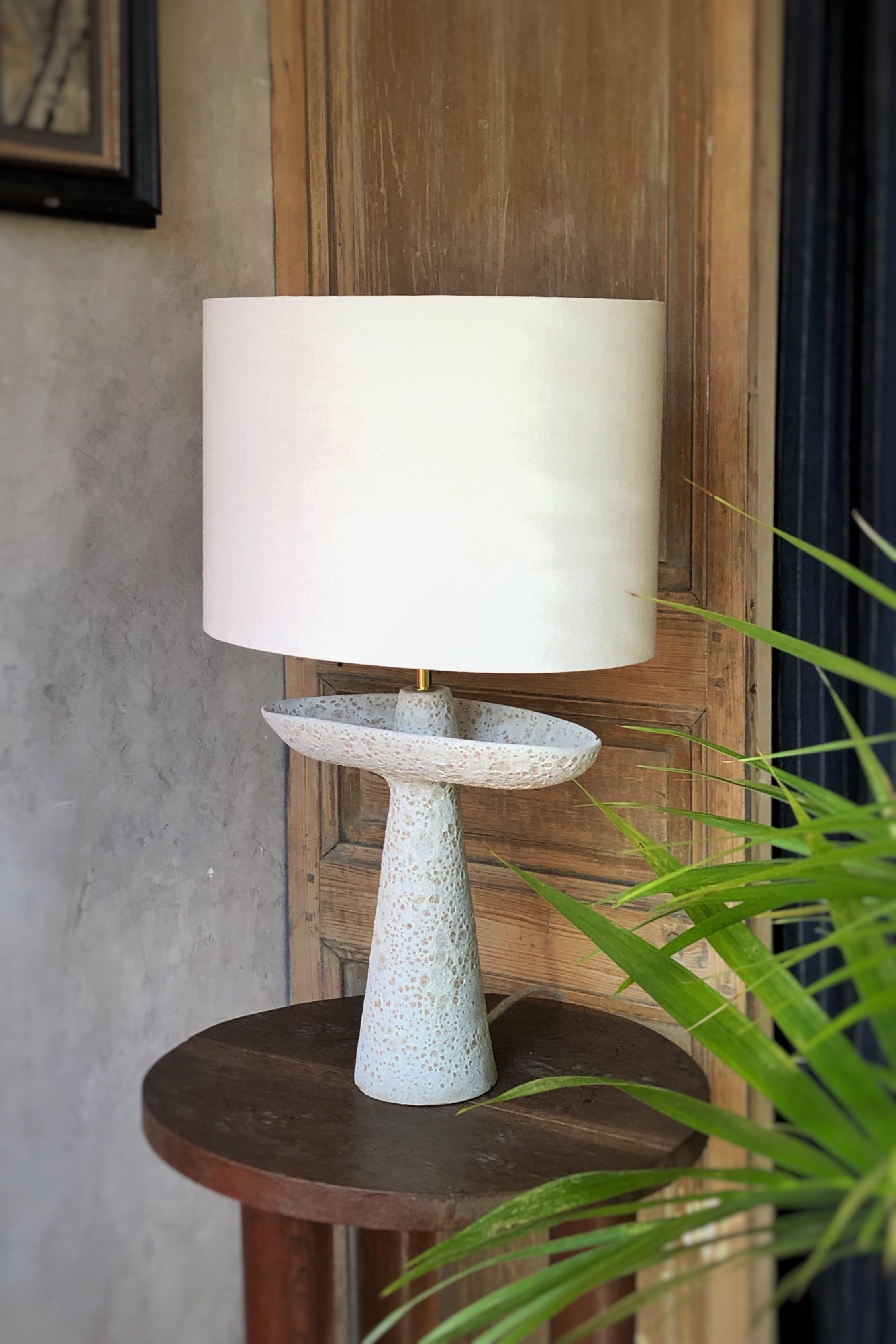 L05 Crater Lamp by Sophie Vaidie
One Of A Kind.
Dimensions: D 28 x W 40 x H 64 cm. 
Materials: Beige stoneware with crater glaze and white linen fabric.

All our lamps can be wired according to each country. If sold to the USA it will be wired for