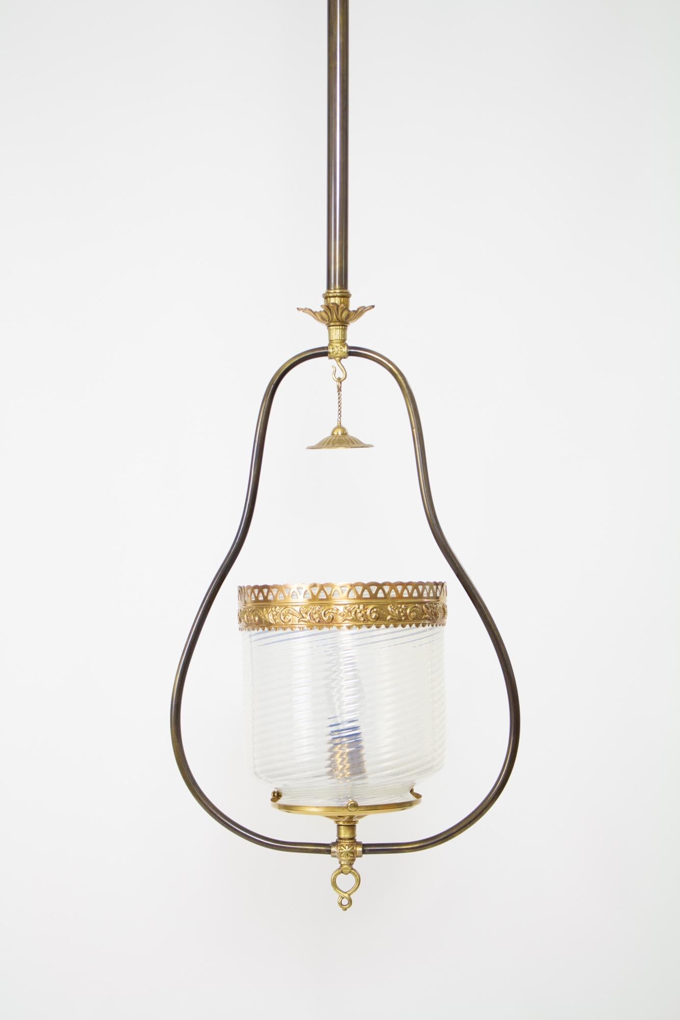 A harp fixture with the original swirled opal glass and smoke bell. Brass filigree crown on glass. Tubing has a dark patina and contrasts with the bright brass detail elements. This piece was originally lit with a gas burner, and has been
