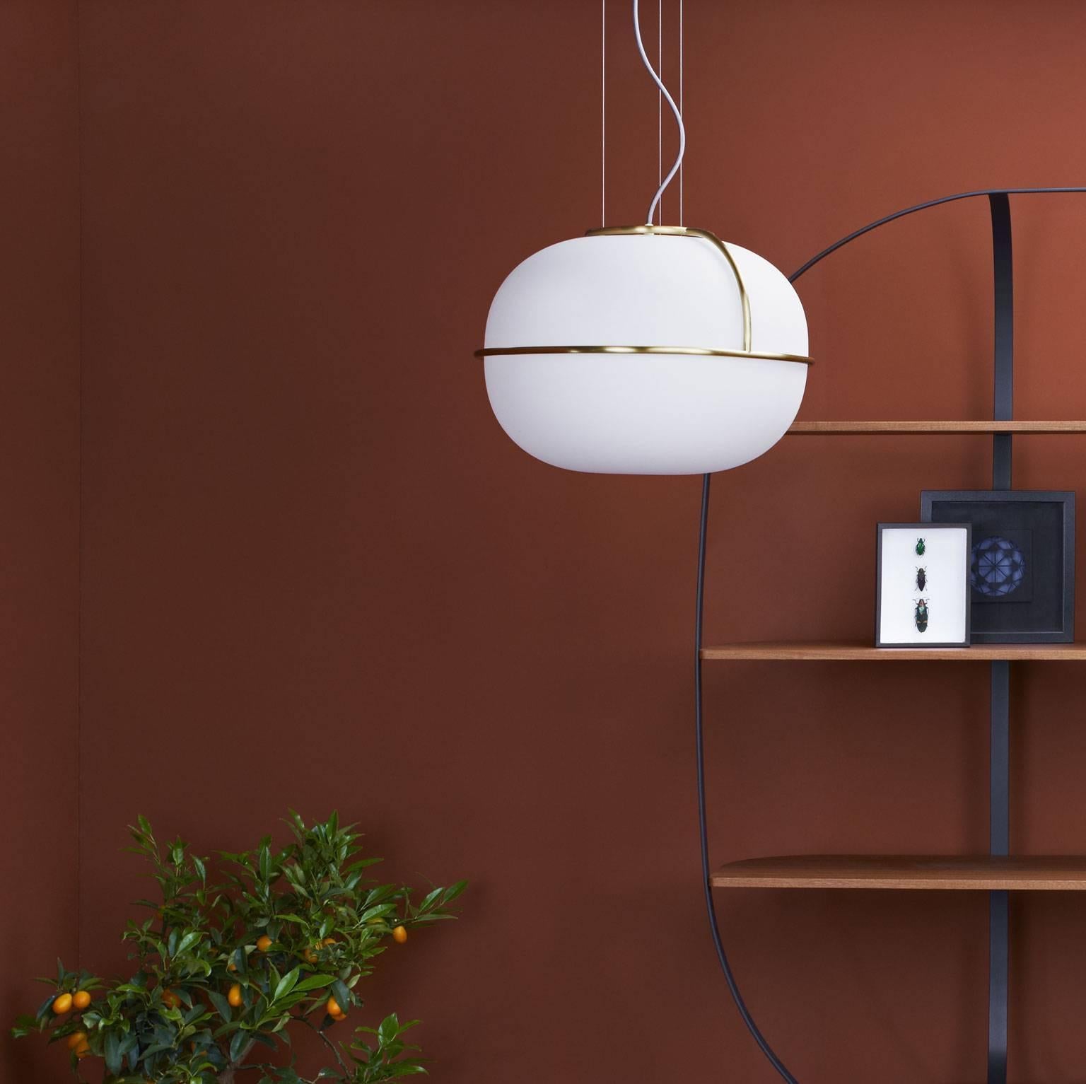 With a design inspired by the classical world of Parisian cafés, the L88 lamp is made of an opal matt white globe encircled by a light frame in brushed brass. Here showcased in the suspension version to diffuse a soft and enveloping light and
