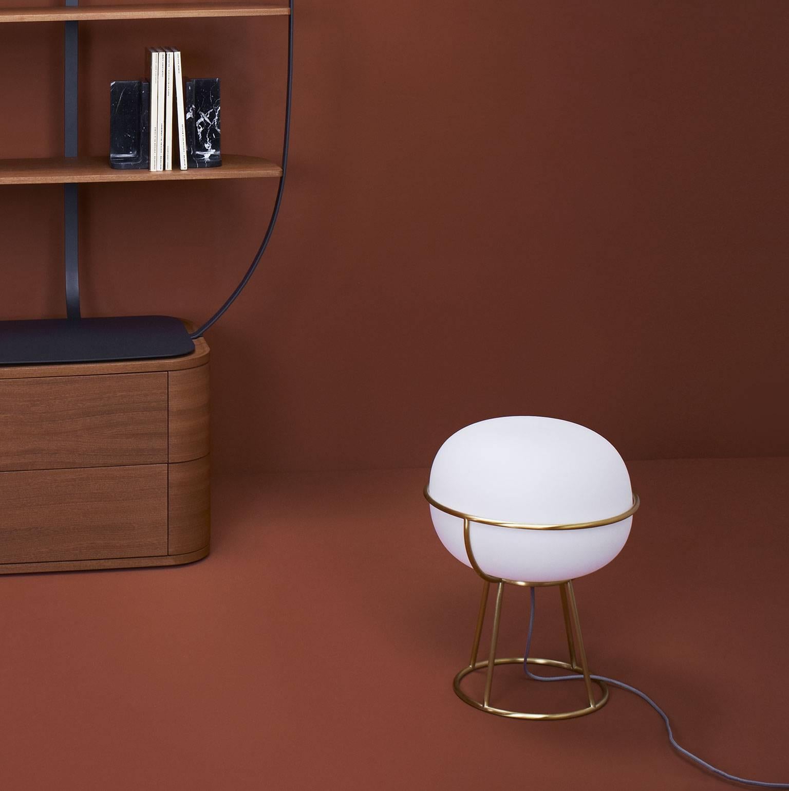 With a design inspired by the classical world of Parisian cafés, the L88 lamp is made of an opal matte white globe encircled by a light frame in brushed brass. Here showcased in the table lamp version to diffuse a soft and enveloping light and
