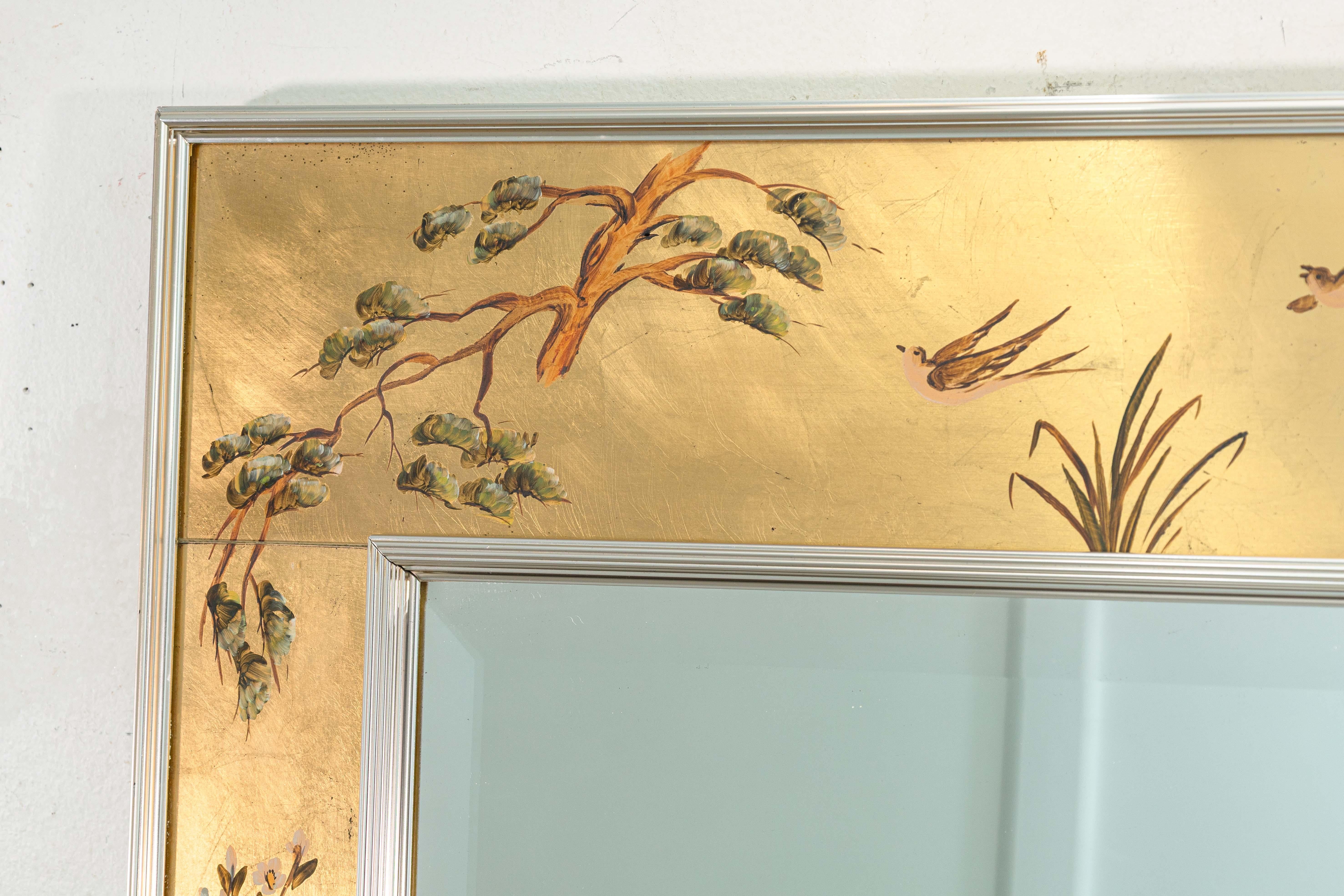 A vintage 1976 La Barge hand painted orante accent mirror. This is a stunning handmade and hand painted wall mirror. It features a chrome accents the the edges of the frame, and a hand painted face surrounding the large rectangular beveled mirror.