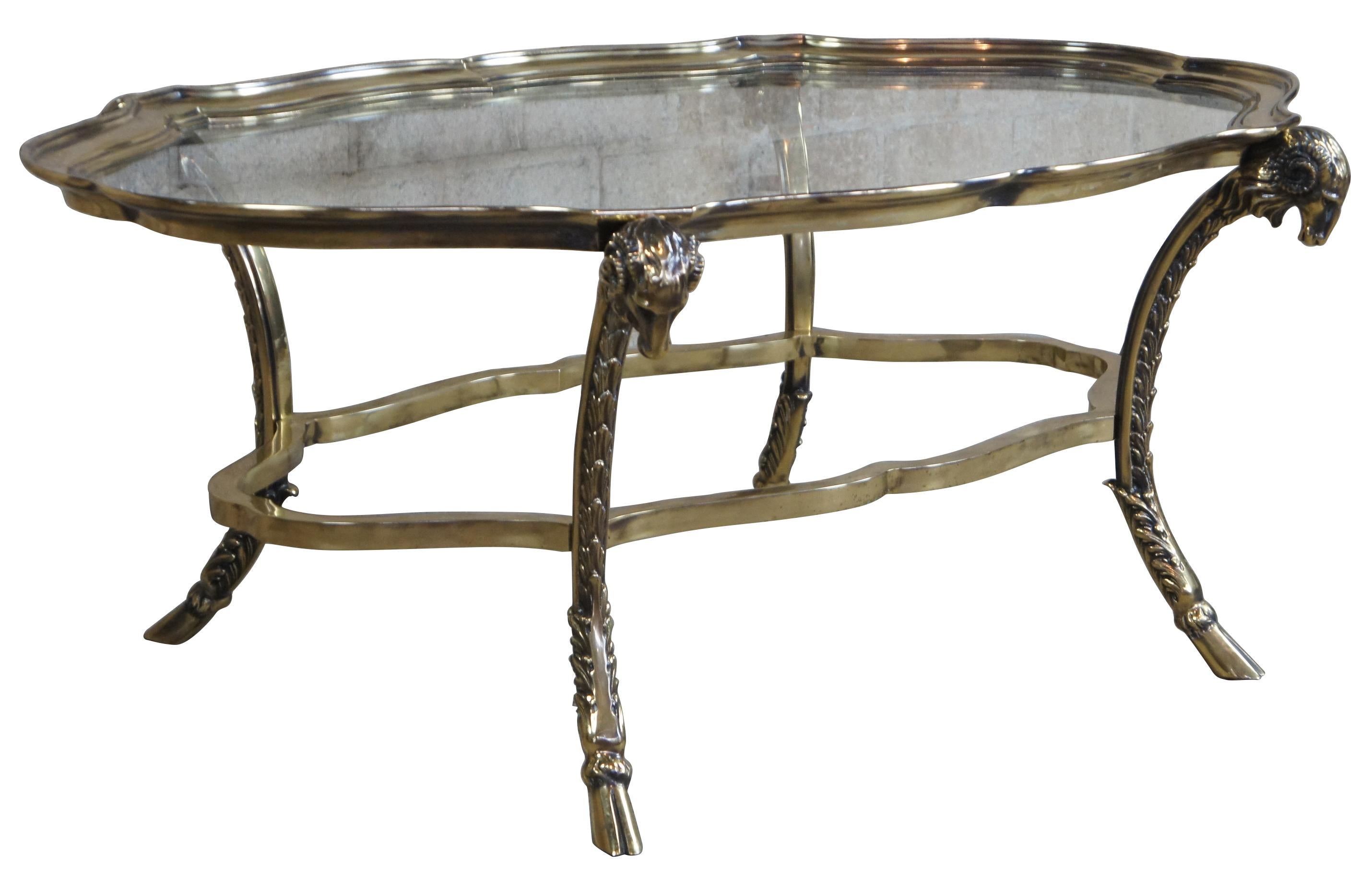 Solid brass sculptural ram's head coffee table in Maison Charles and Hollywood Regency style. Features scalloped edge border and intricately detailed ram's head table festering hove feet.
  